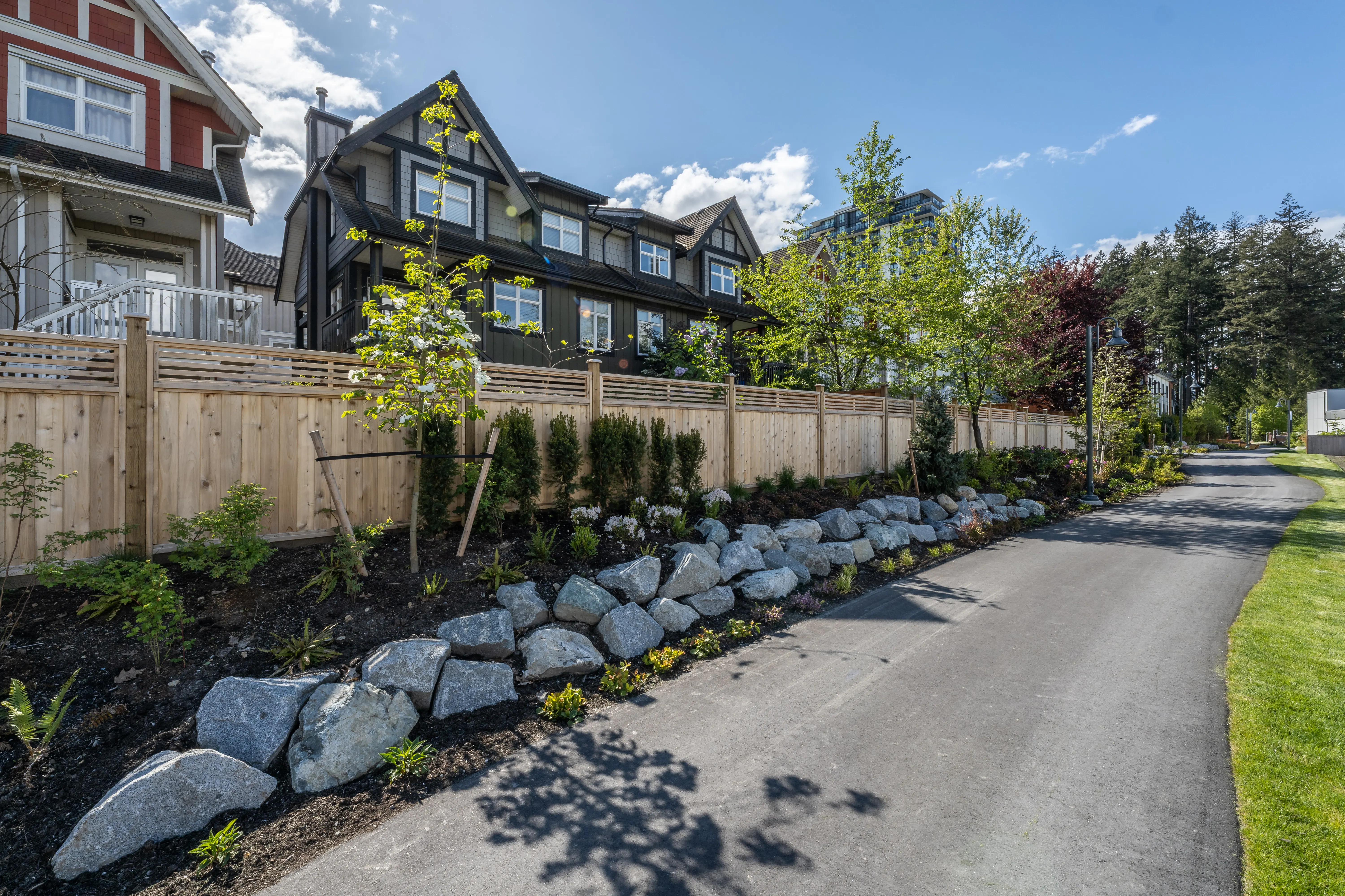 Paved trail with boulder edging and planting beside townhomes at Community Green and Ortona Trail