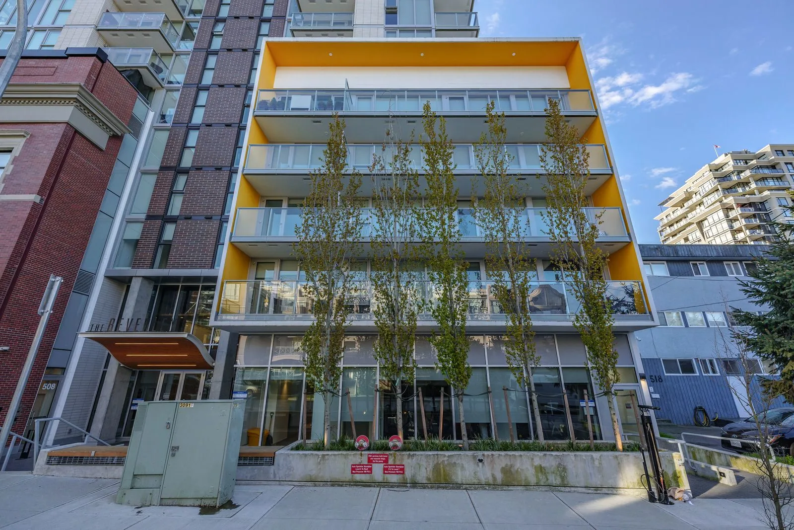Columnar trees along the frontage of a residential building at The Beverley