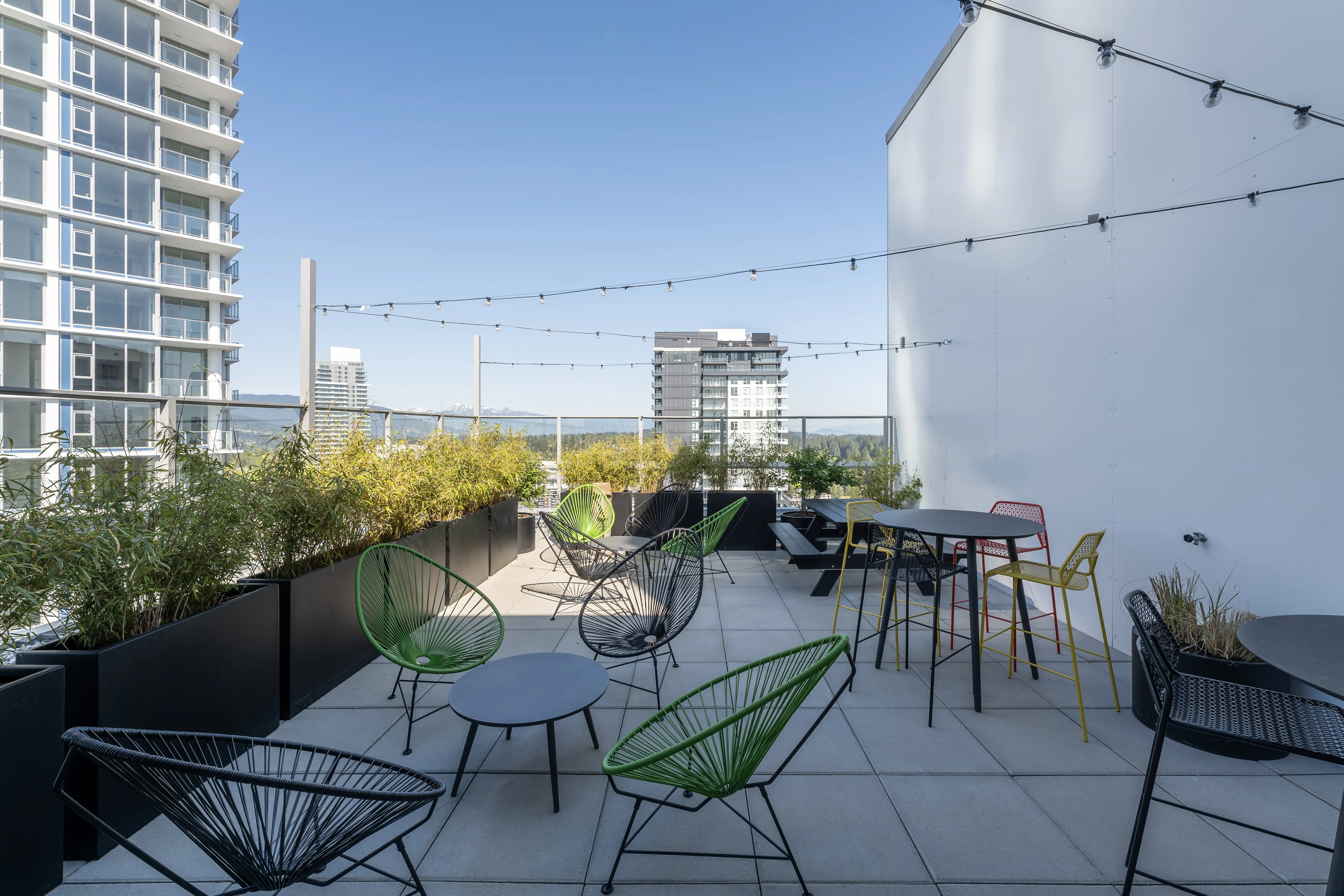 Rooftop patio with chairs, planters and string lights at Meridian