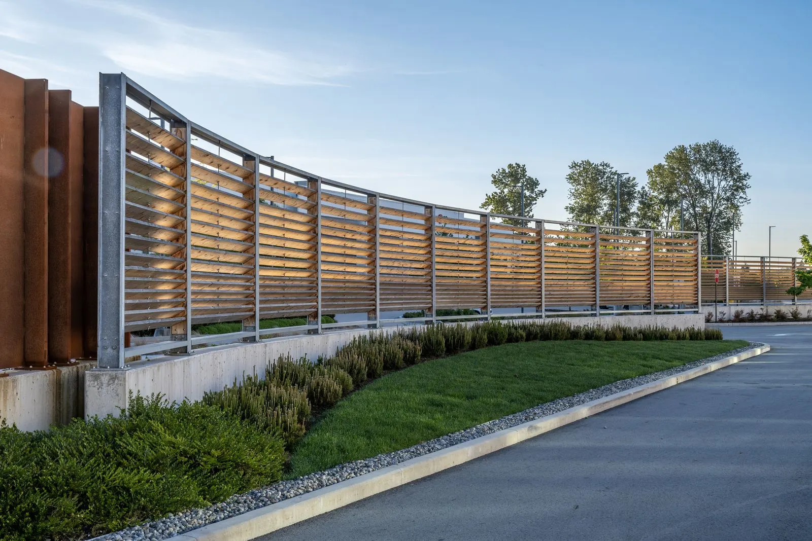 Curved timber screen wall and lawn along a driveway at Riverbend Amazon Warehouse