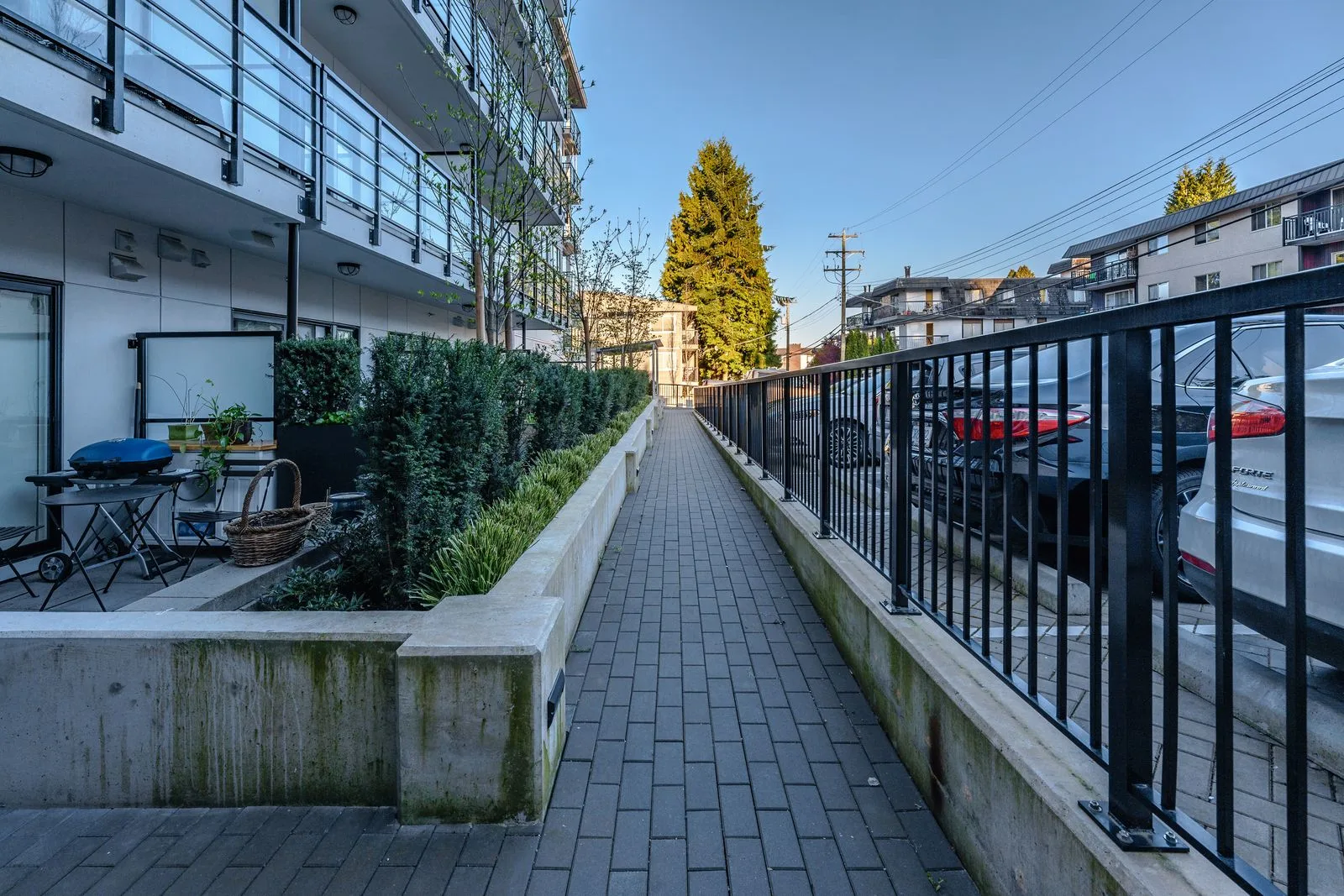 Paver walkway between patios and a metal fence at The Saint George