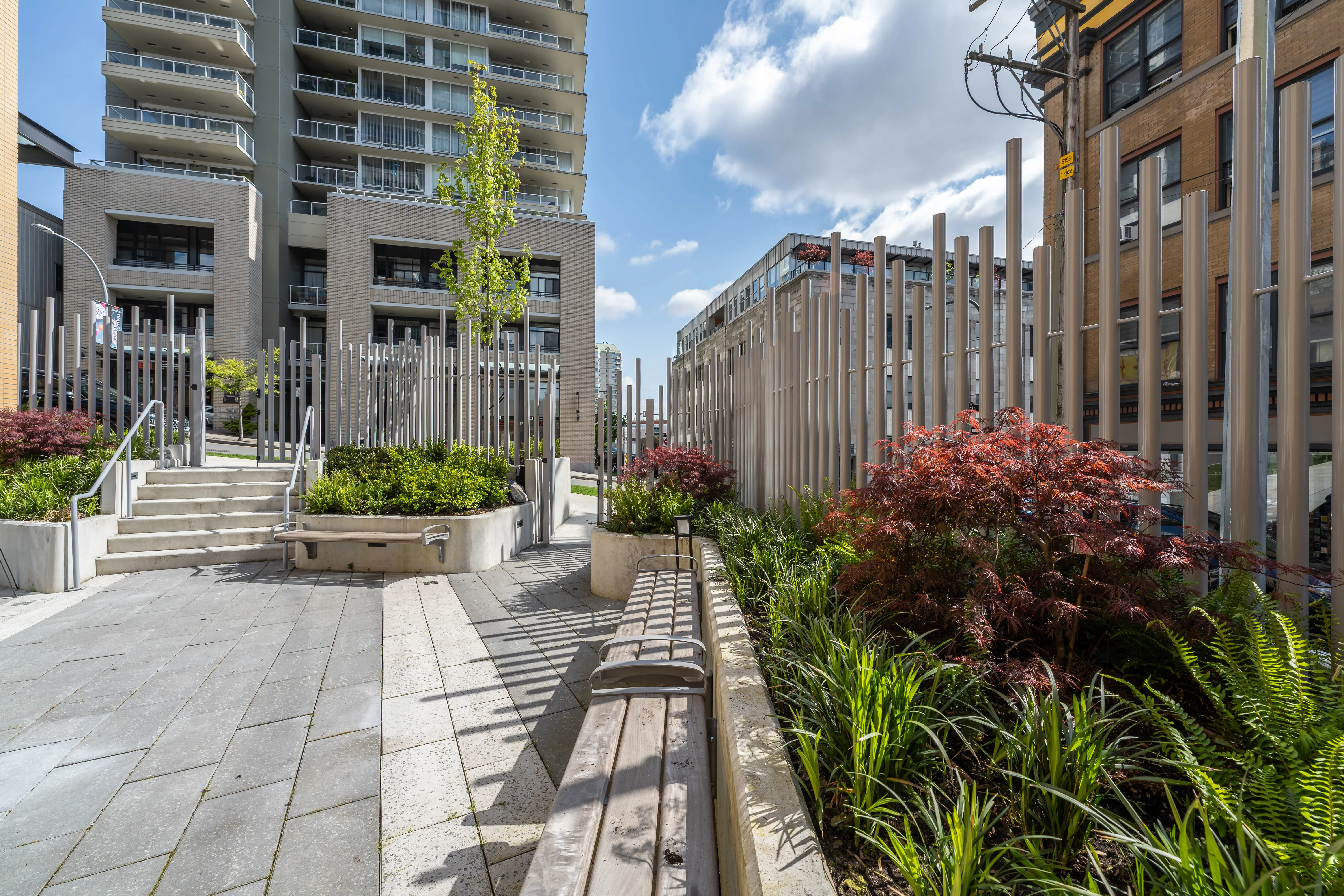 Planted walkway with timber benches and vertical posts at 618 Carnarvon
