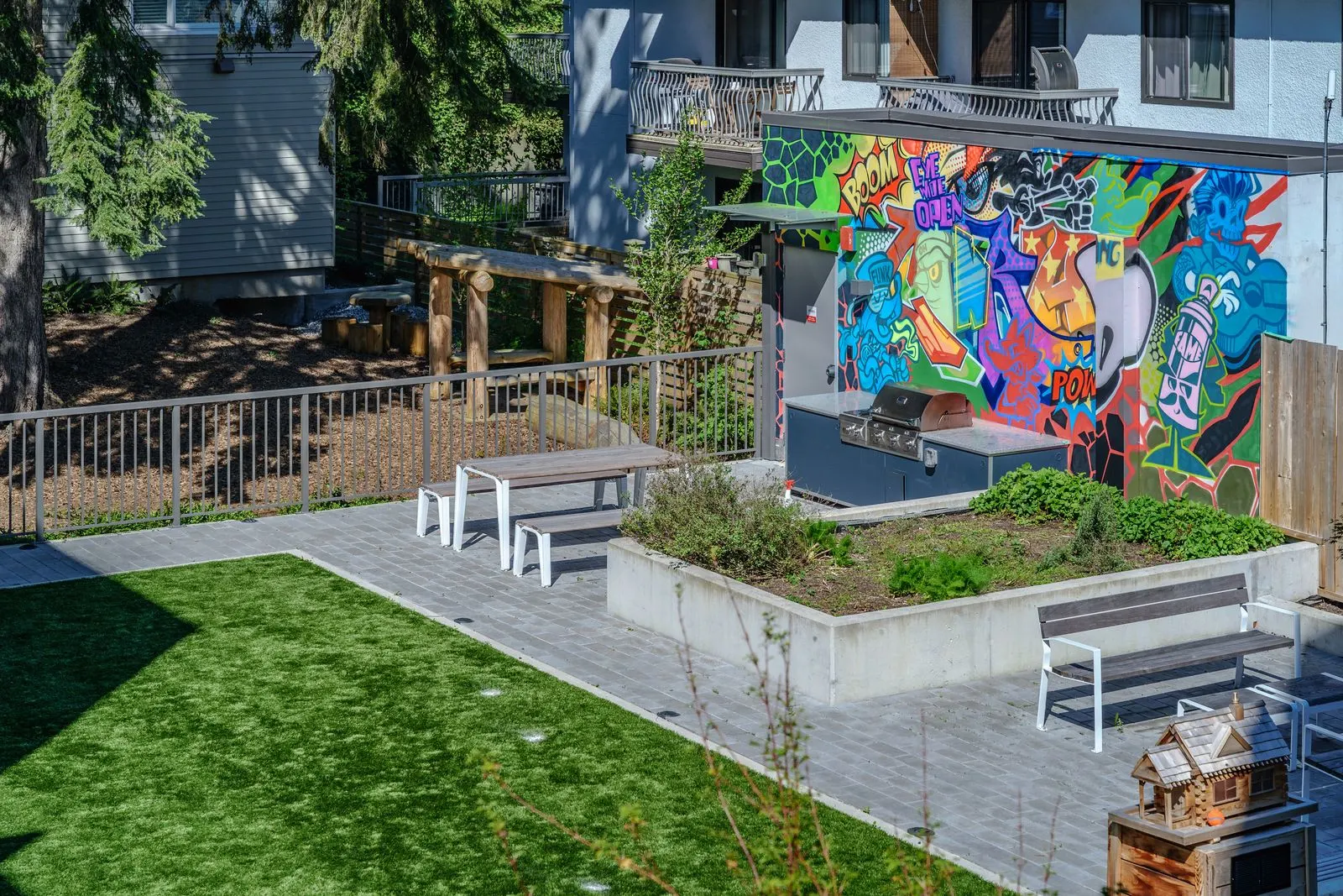 Courtyard lawn, raised planters and a mural wall at Conrad