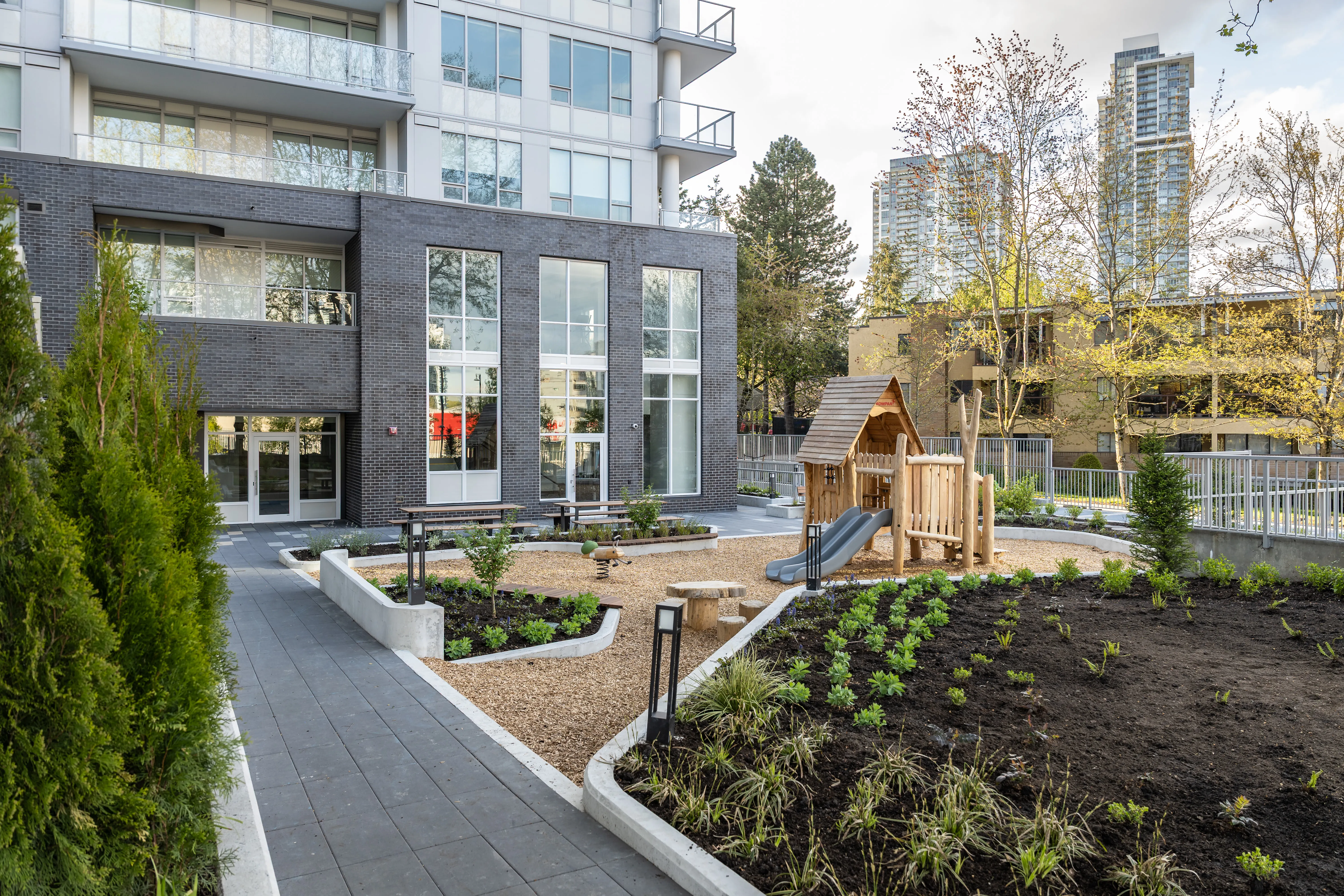 Walkway and new planting beds beside a play area at The Holland II