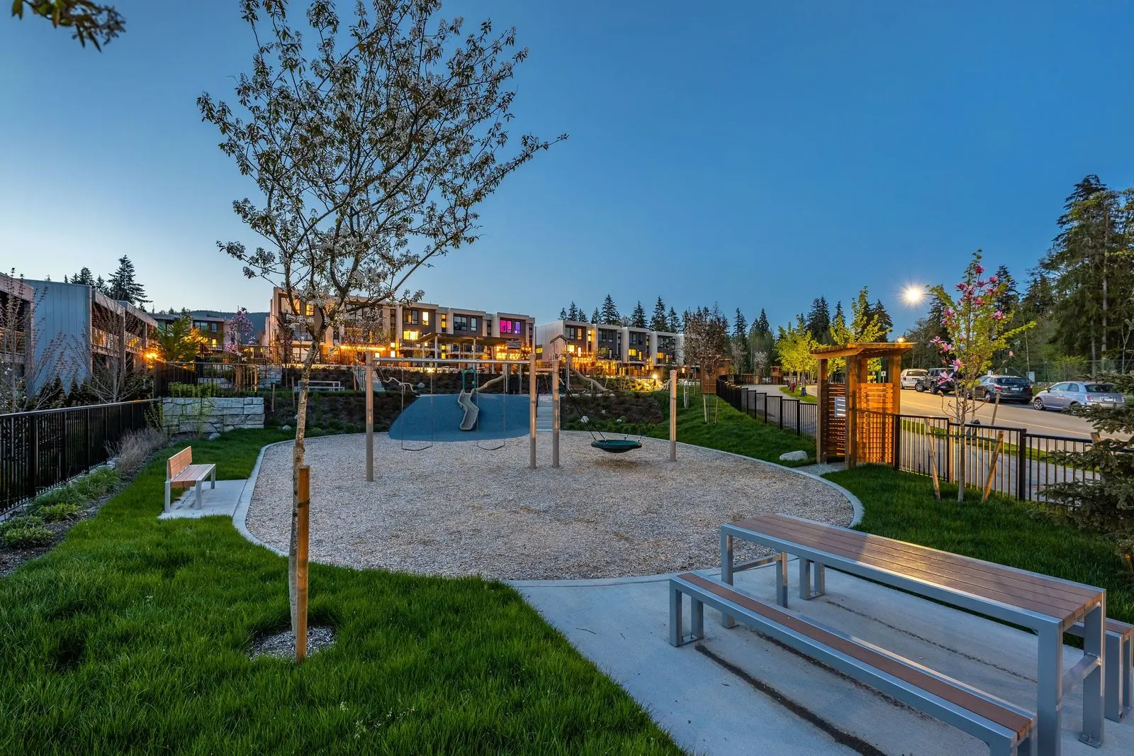 Lawn, benches and sand play area at dusk at Seymour Village Amenity Park