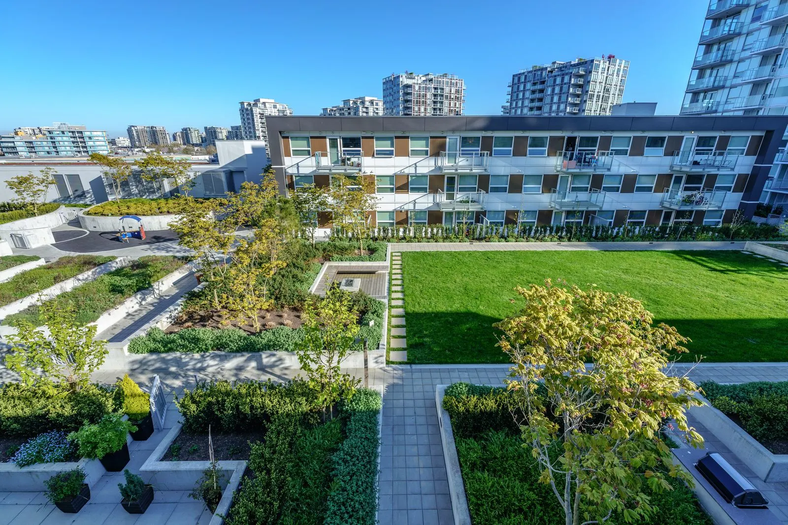 Courtyard lawn with planting beds and pathways at River Park Place 2