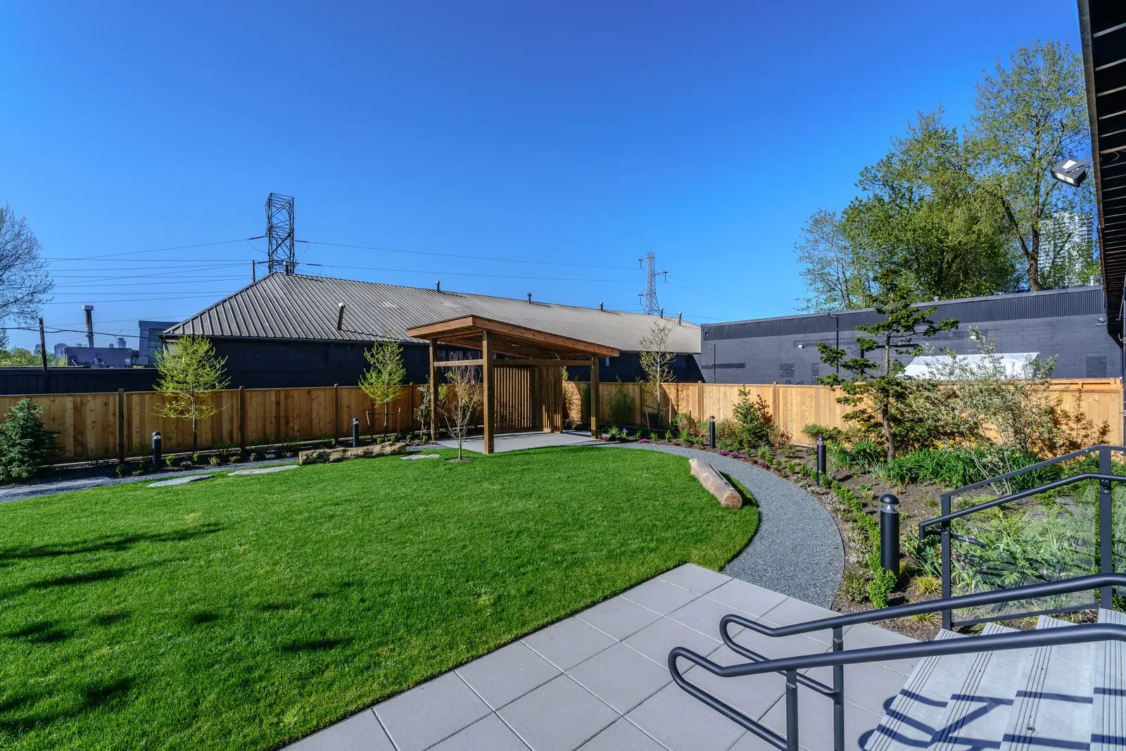 Lawn and walkway beside a timber fence at The Grove Presentation Centre