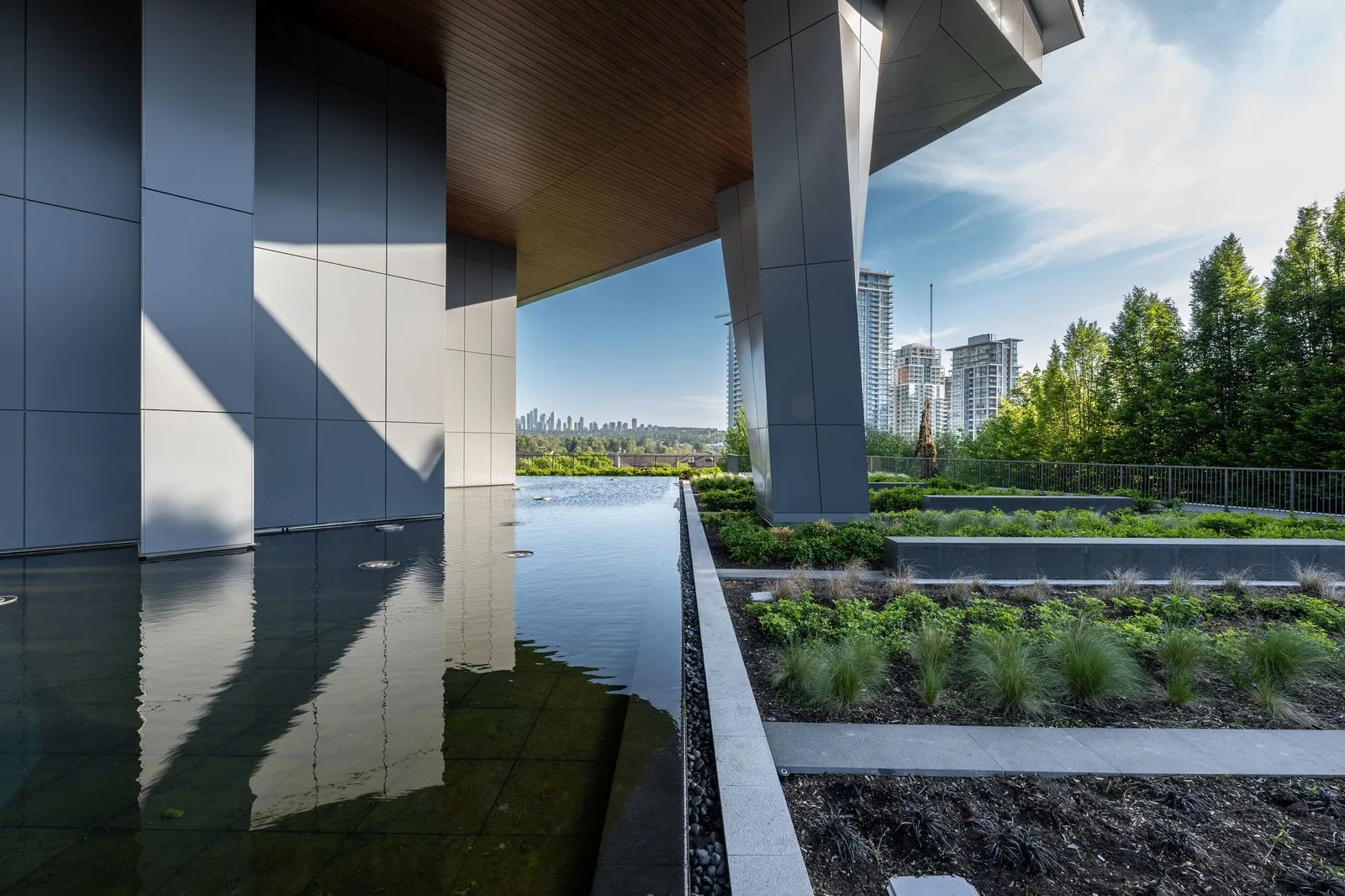 Reflecting pool and planting beneath a tower overhang at Brentwood 1A