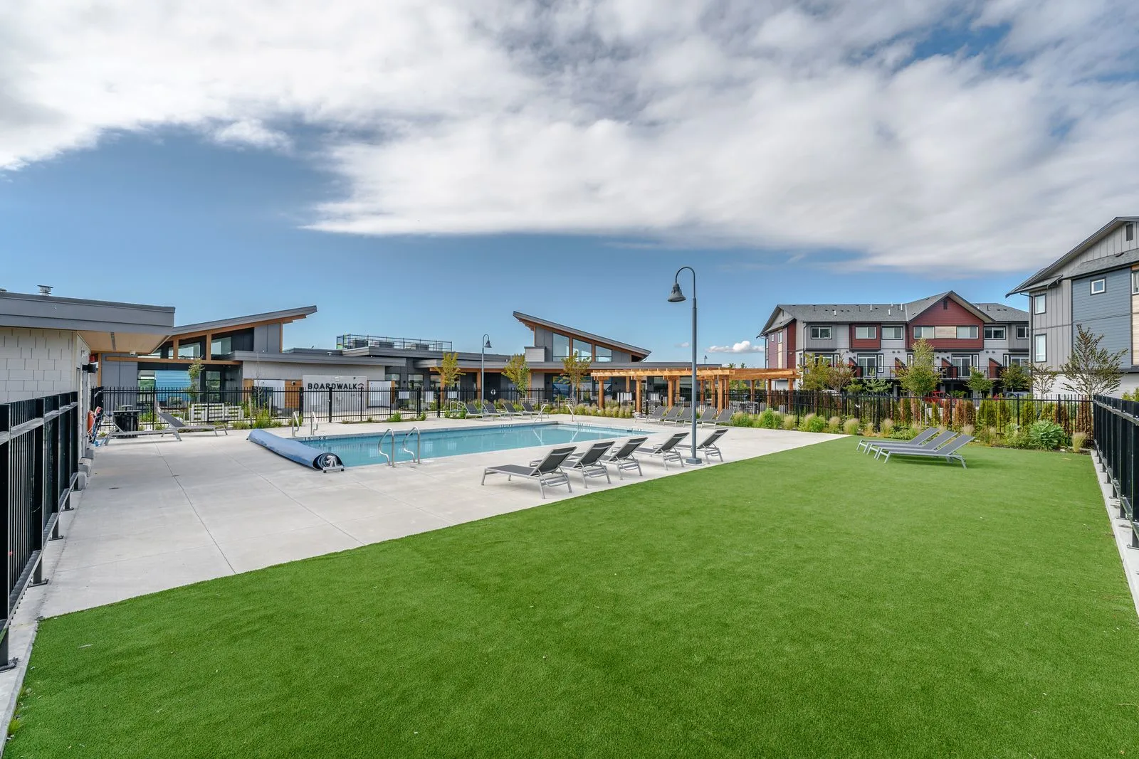 Lawn and pool deck with lounge chairs at Boardwalk