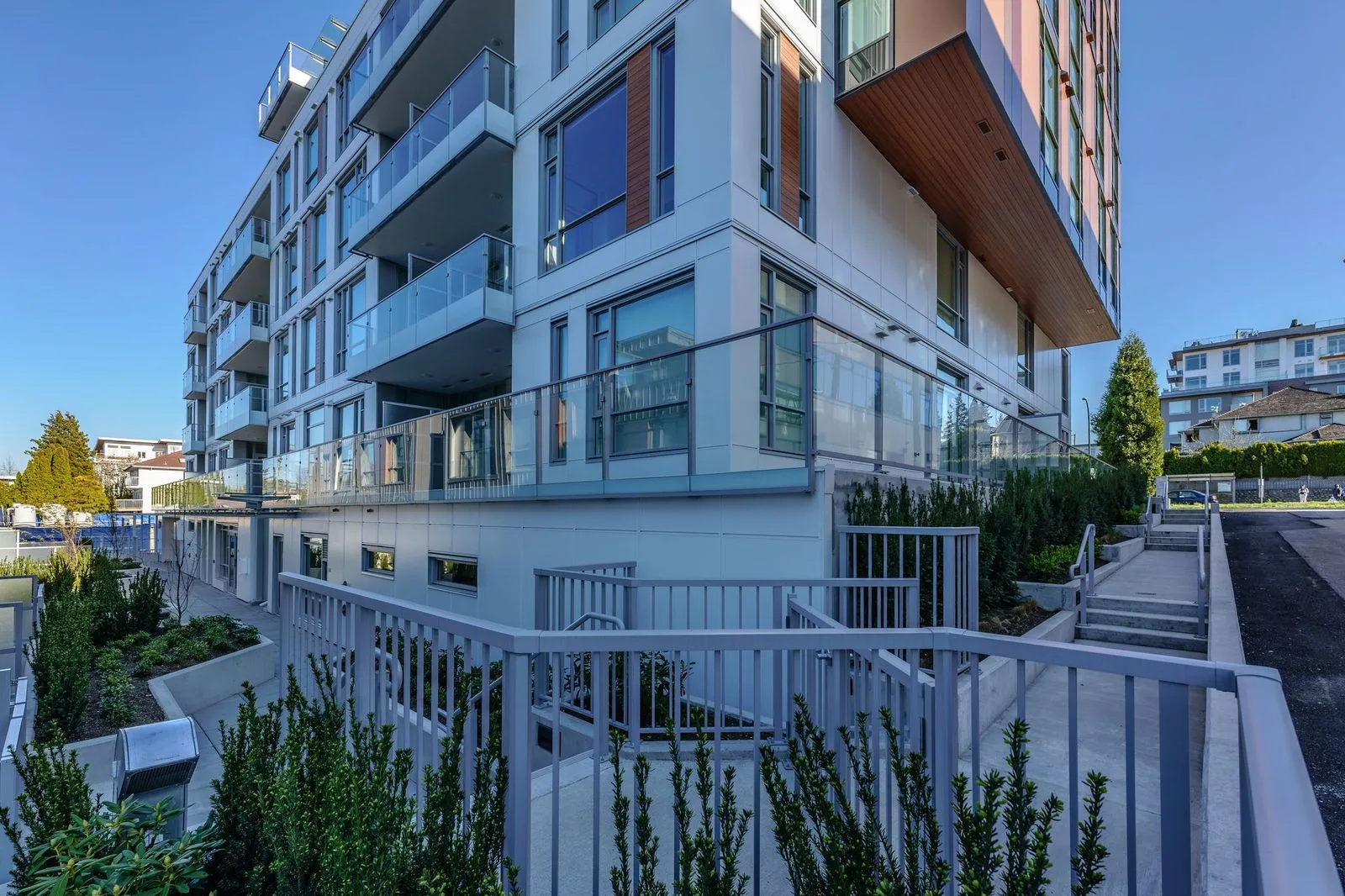 Entry ramp railings and planting beside a residential building at Marquise