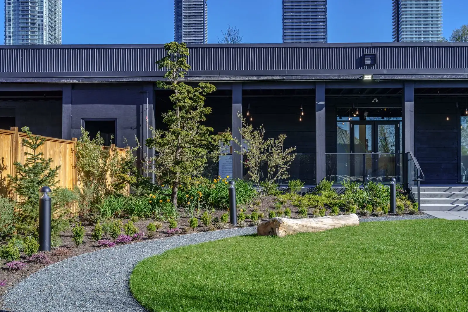 Curved lawn edged by gravel path and planting at The Grove Presentation Centre