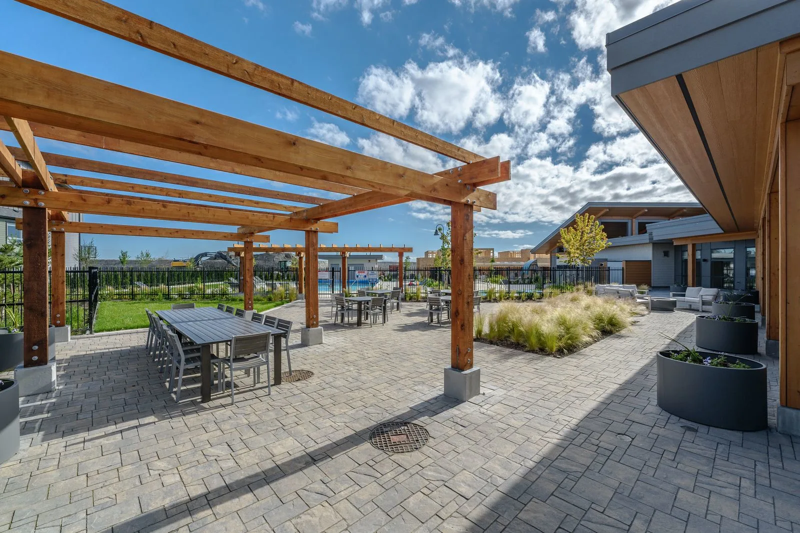 Timber pergola over a paver patio with dining tables at Boardwalk