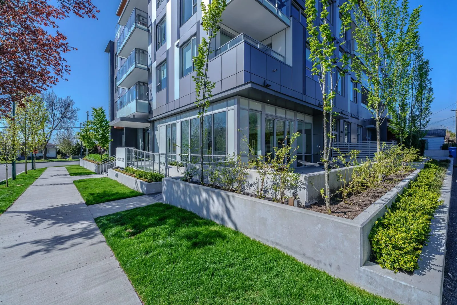 Lawn and raised planters along a residential walkway at The Parker