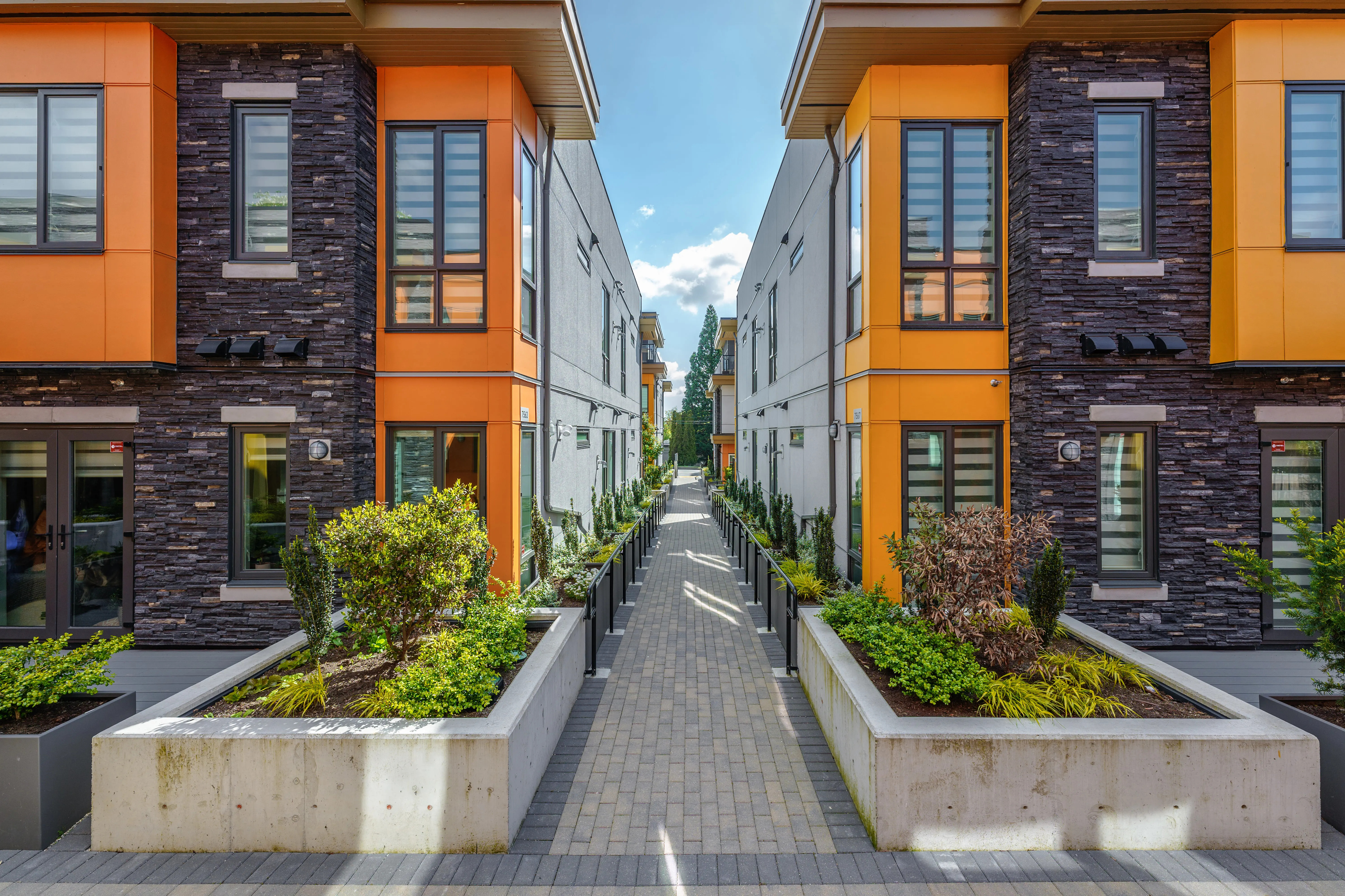 Raised concrete planters along a paved lane between townhomes at Terraces at Oak Park