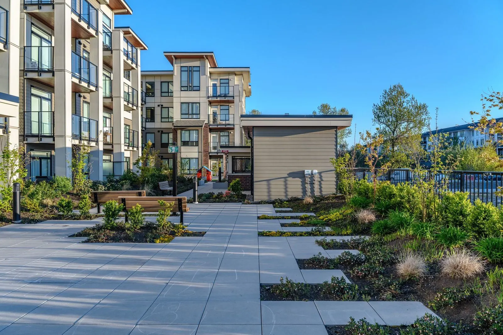 Paved courtyard with benches and planting beds at Spark