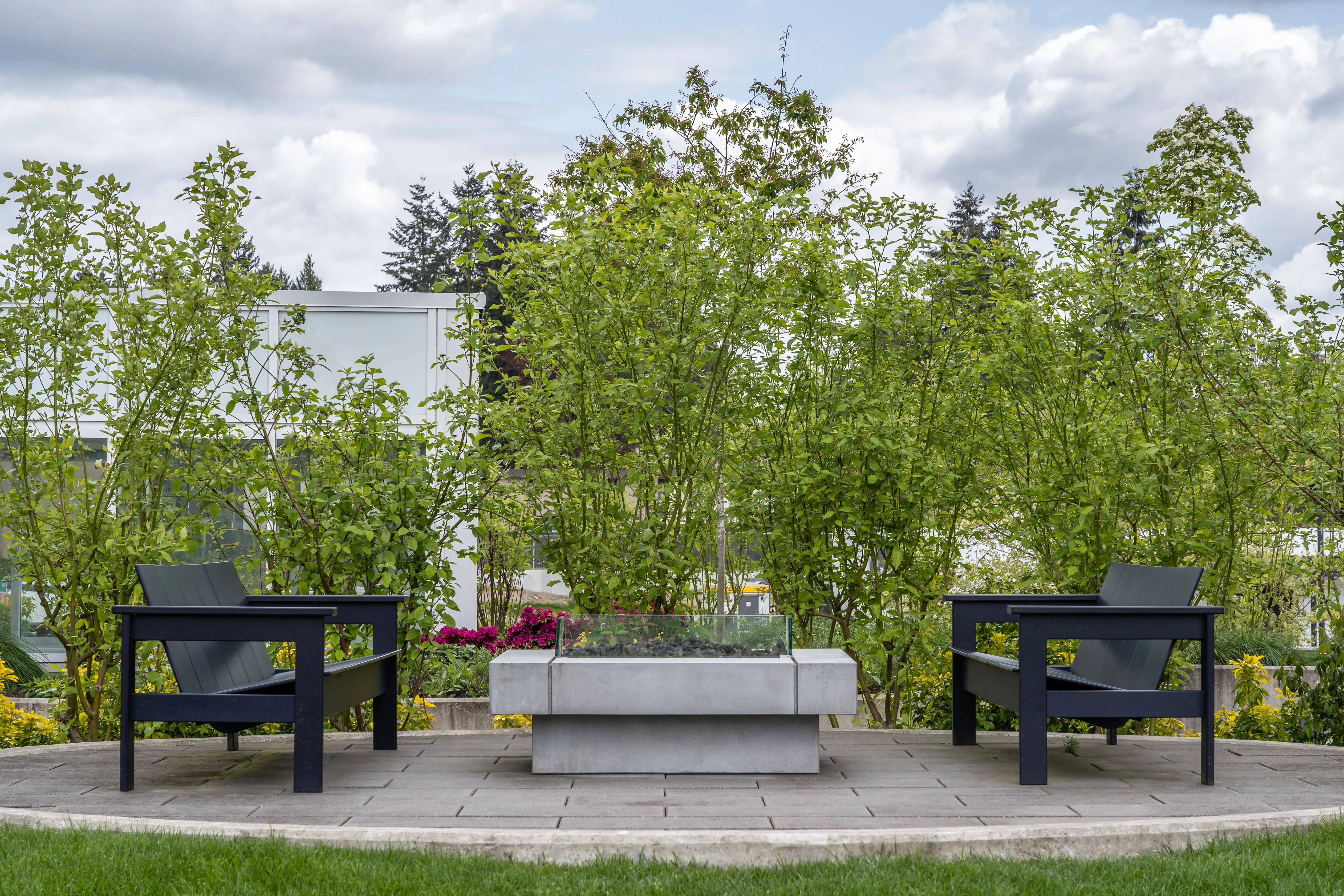 Outdoor lounge chairs around a fire table on a lawn at Georgetown