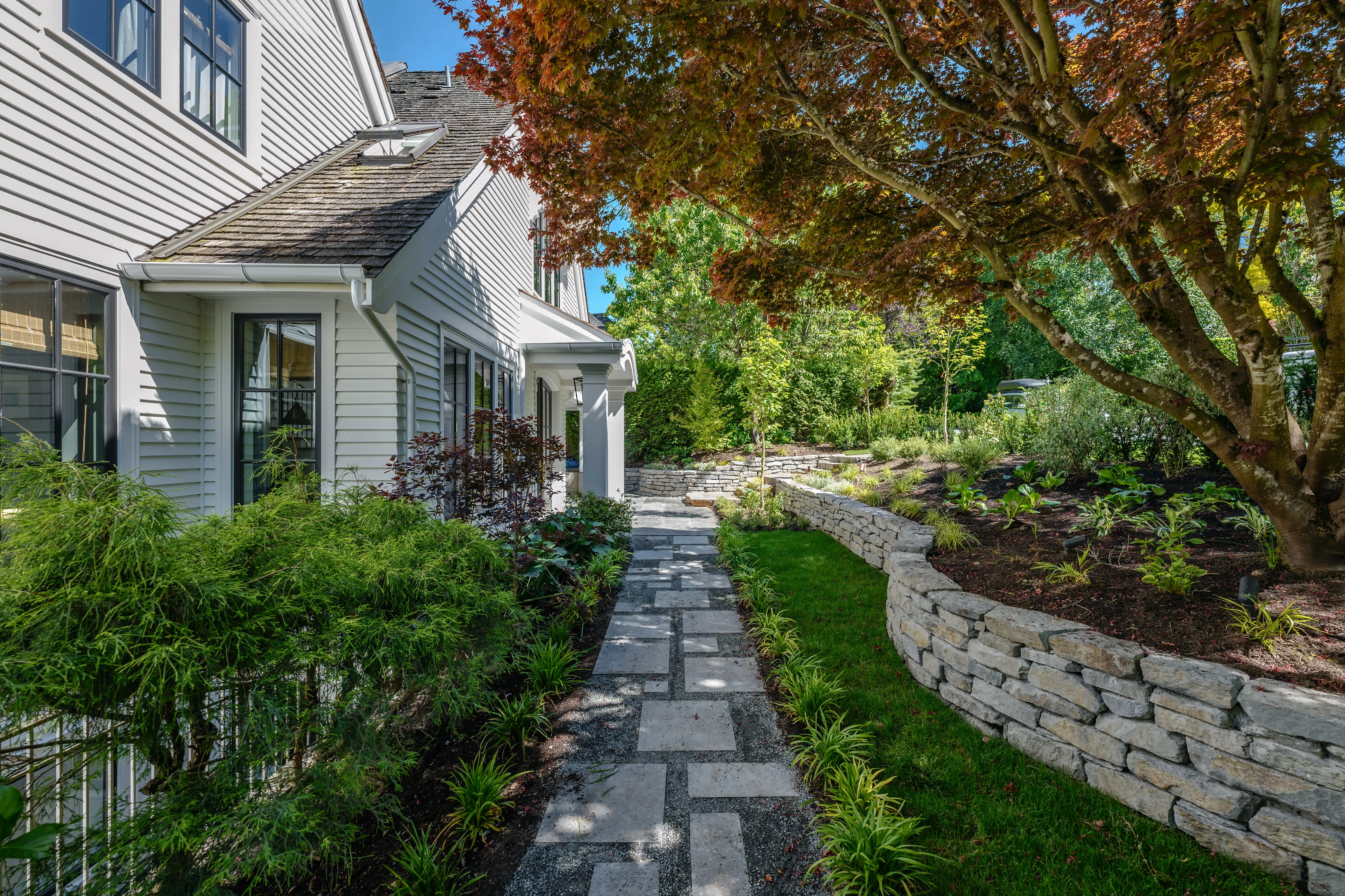 Stepping stone path beside a stacked stone wall and planting at MacKenzie