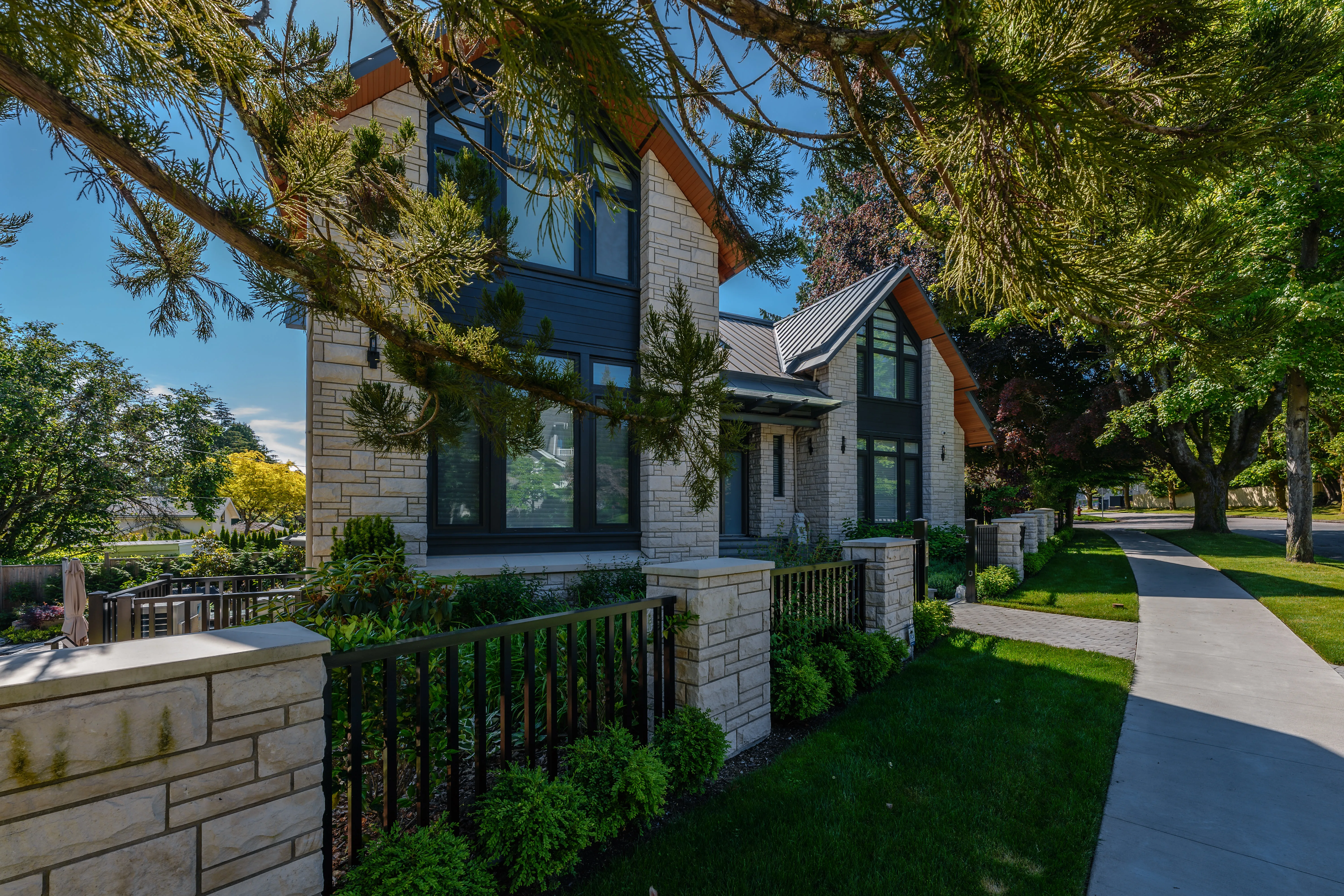 Front yard lawn and fence at a stone-clad house at Hudson Street