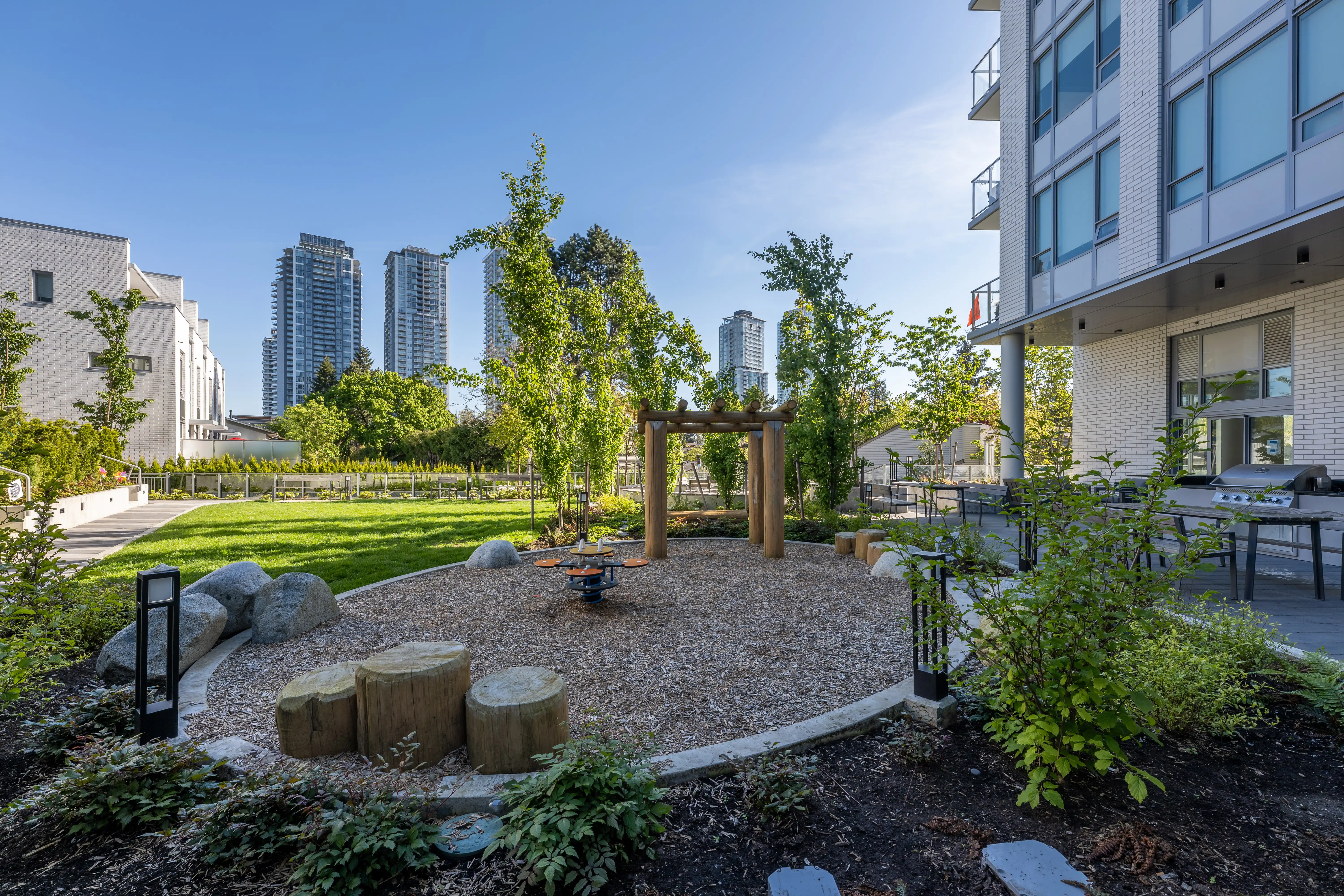Sand play area with log stumps and timber frame in a courtyard at The Holland I