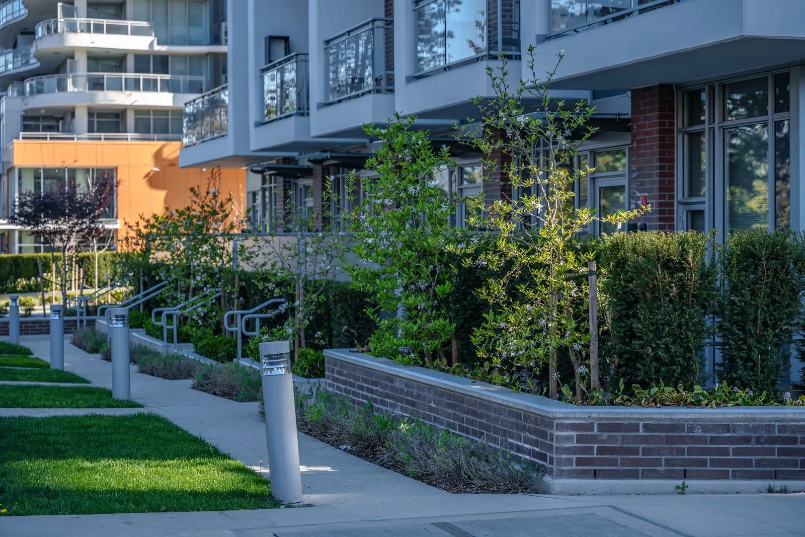 Brick planters, lawn and bollard lights at townhome entries at Evolve