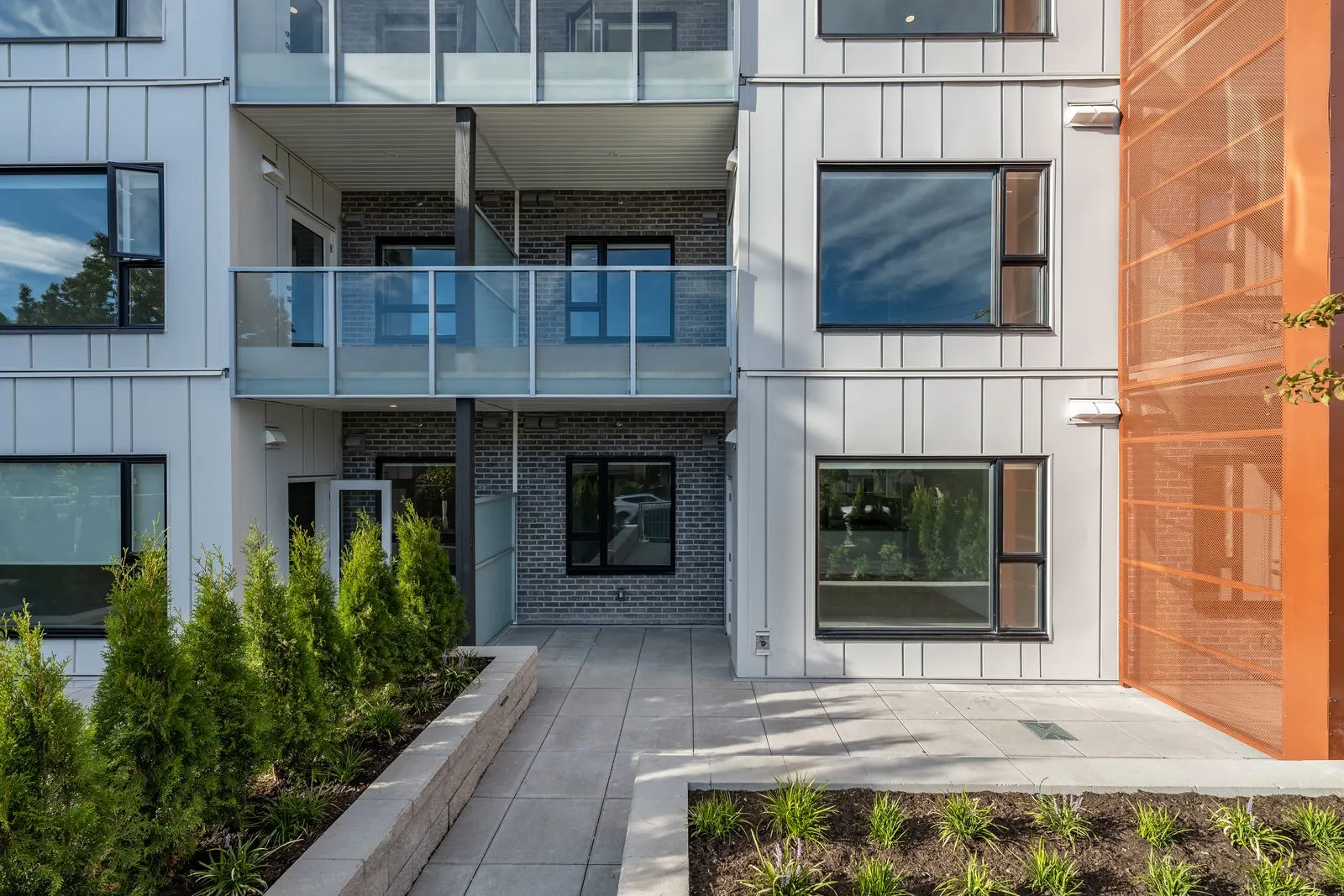 Planting beds and paved entry at a residential building at Alba Rindall