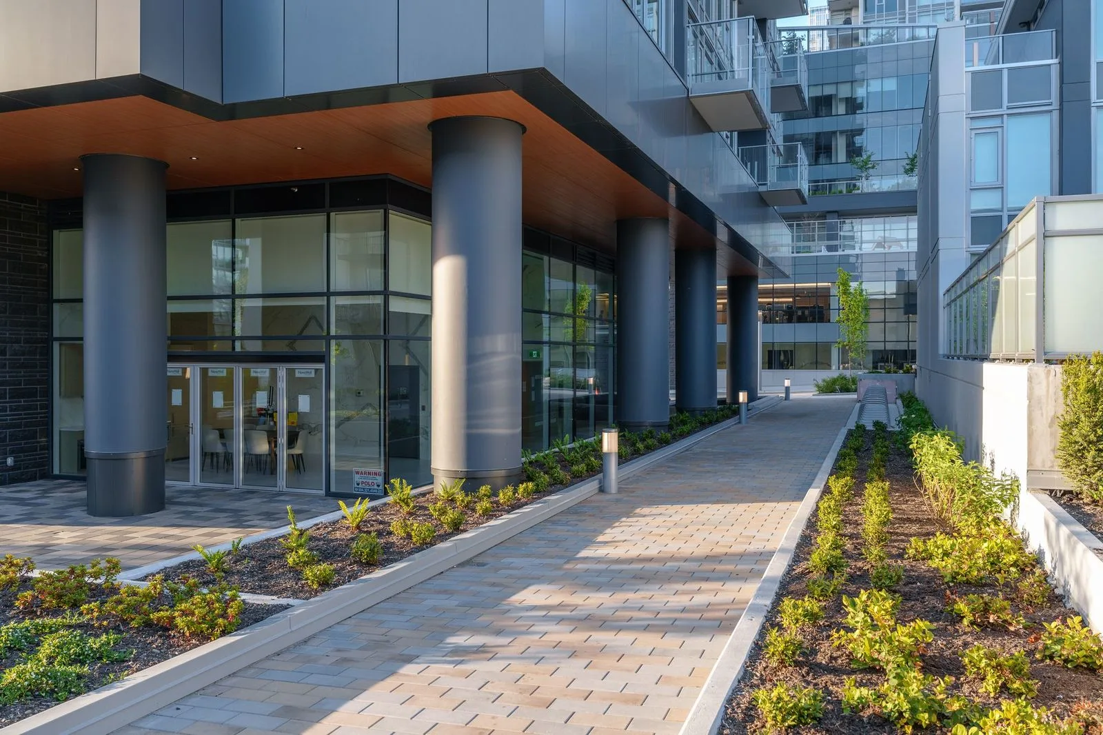 Paver walkway lined with planting beds at a tower entrance at Sun Tower II