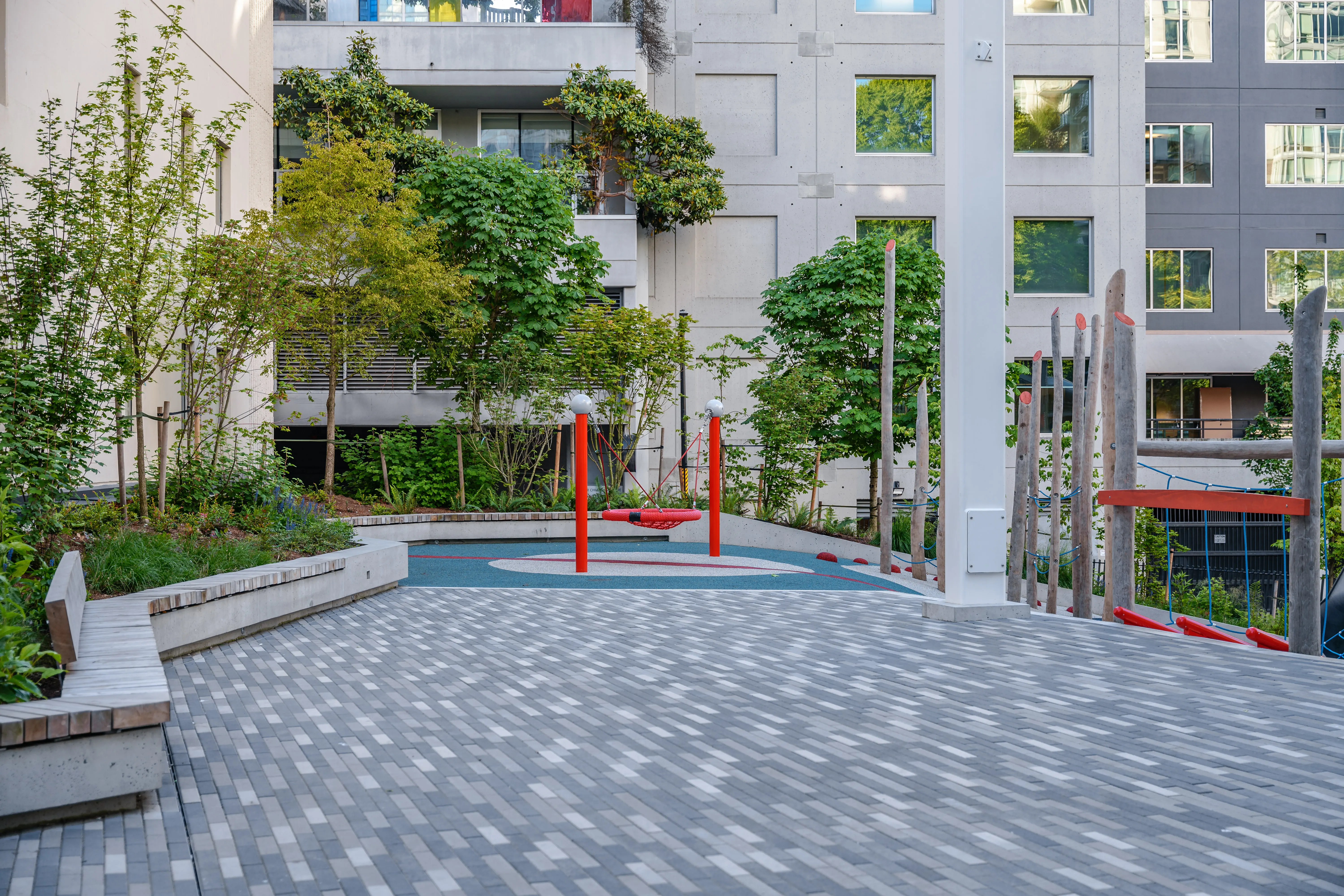 Paved plaza and play area with planting at Rainbow Park Downtown