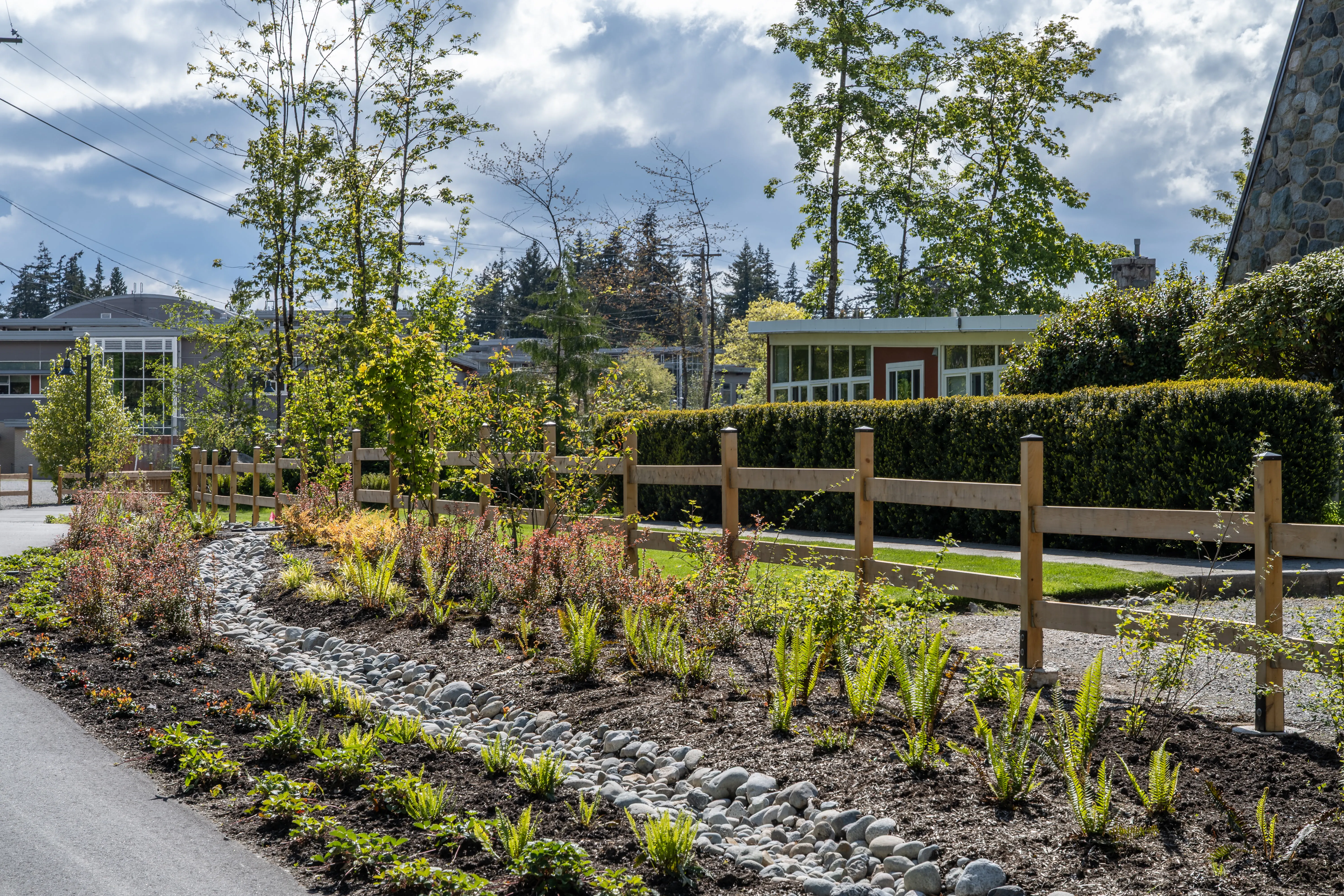 Dry creek bed and planting beside a timber rail fence at Community Green and Ortona Trail