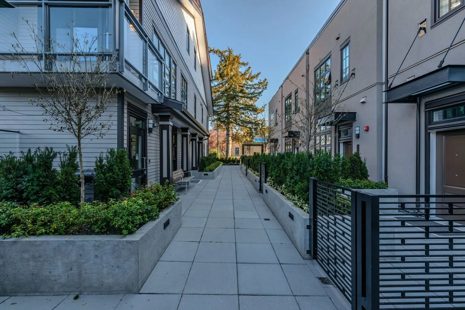 Paved walkway between townhomes with raised planters at Westbury Townhomes