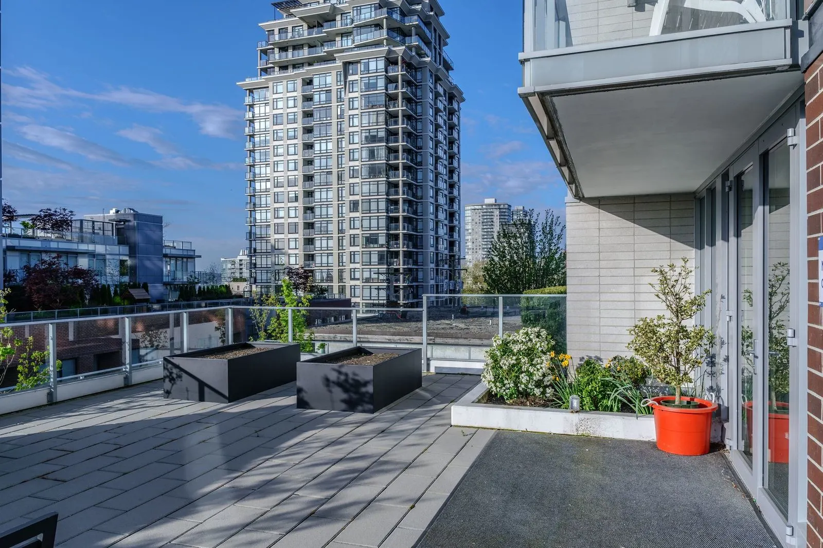 Rooftop patio with planters and seating with city views at The Beverley