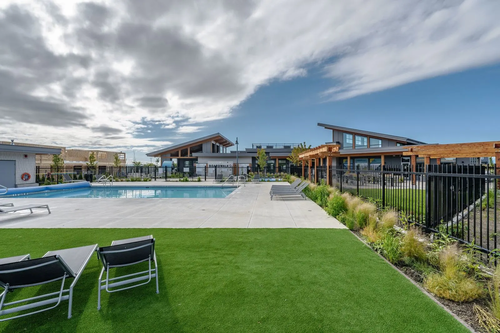 Lawn with lounge chairs beside the pool deck at Boardwalk