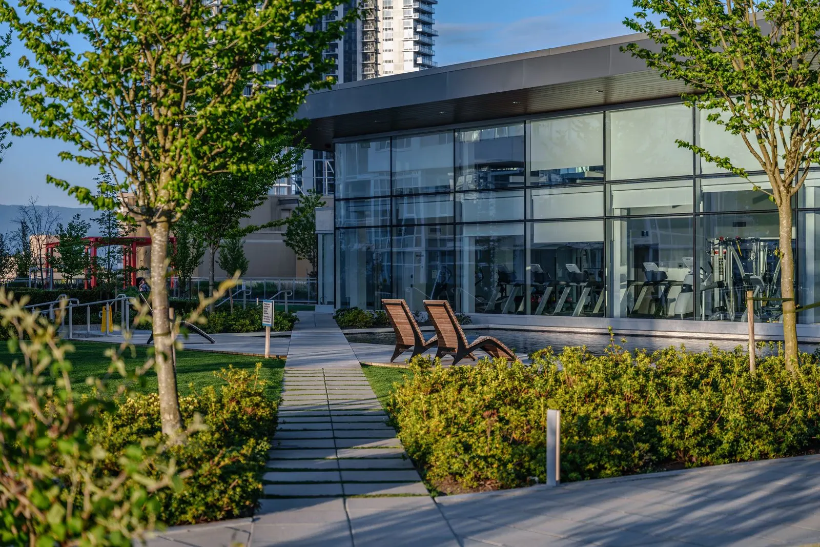 Paved path through planting beds to an amenity building at Station Square 2 and 3