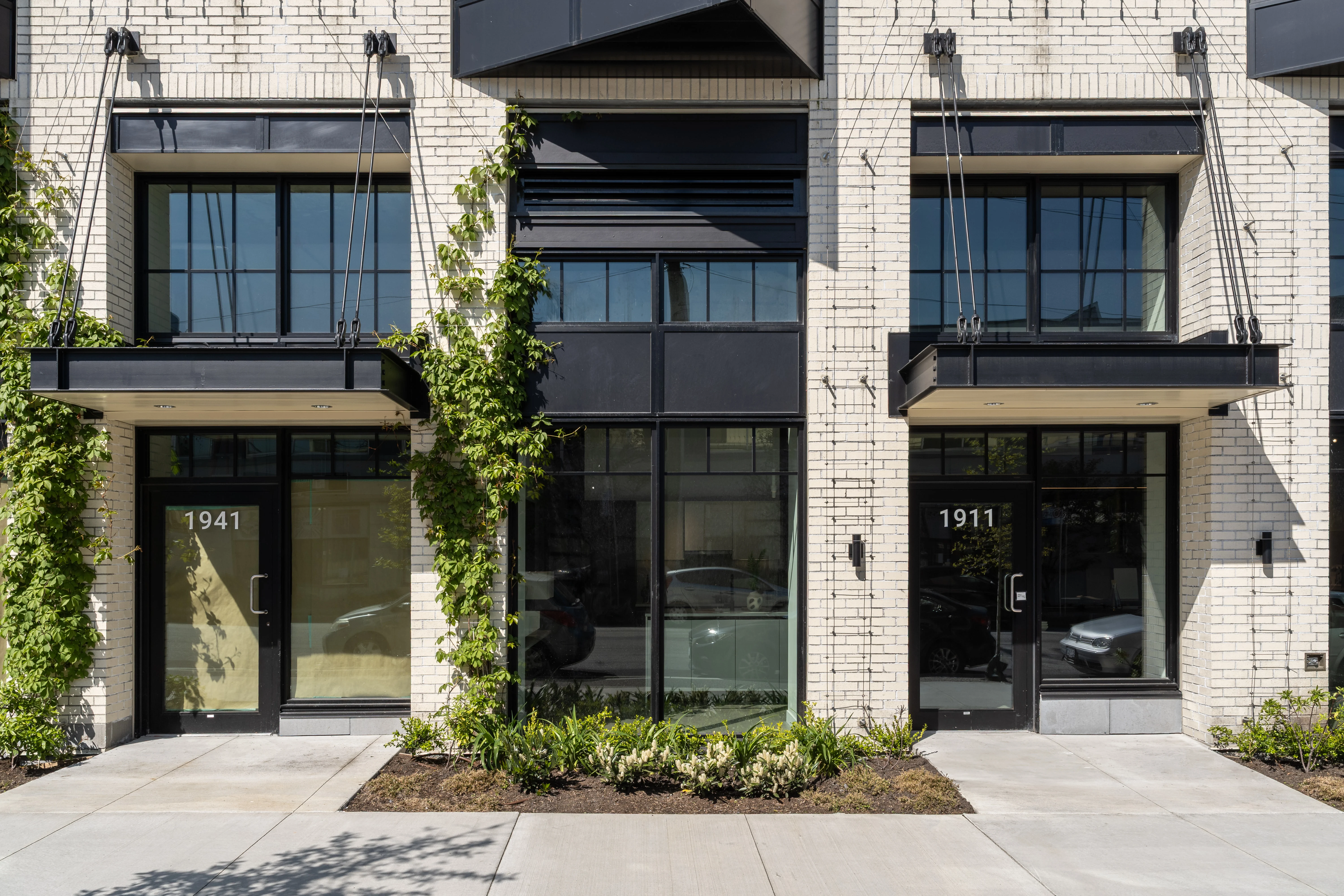 Climbing vines and low planting at commercial unit entries at Ofisworks
