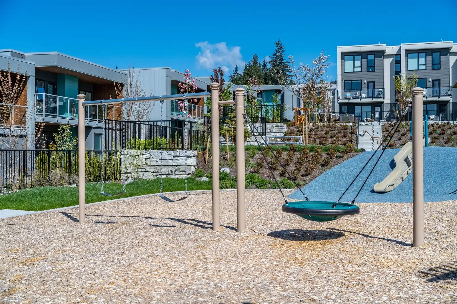 Nest swing and swing set on a sand play area at Seymour Village Amenity Park