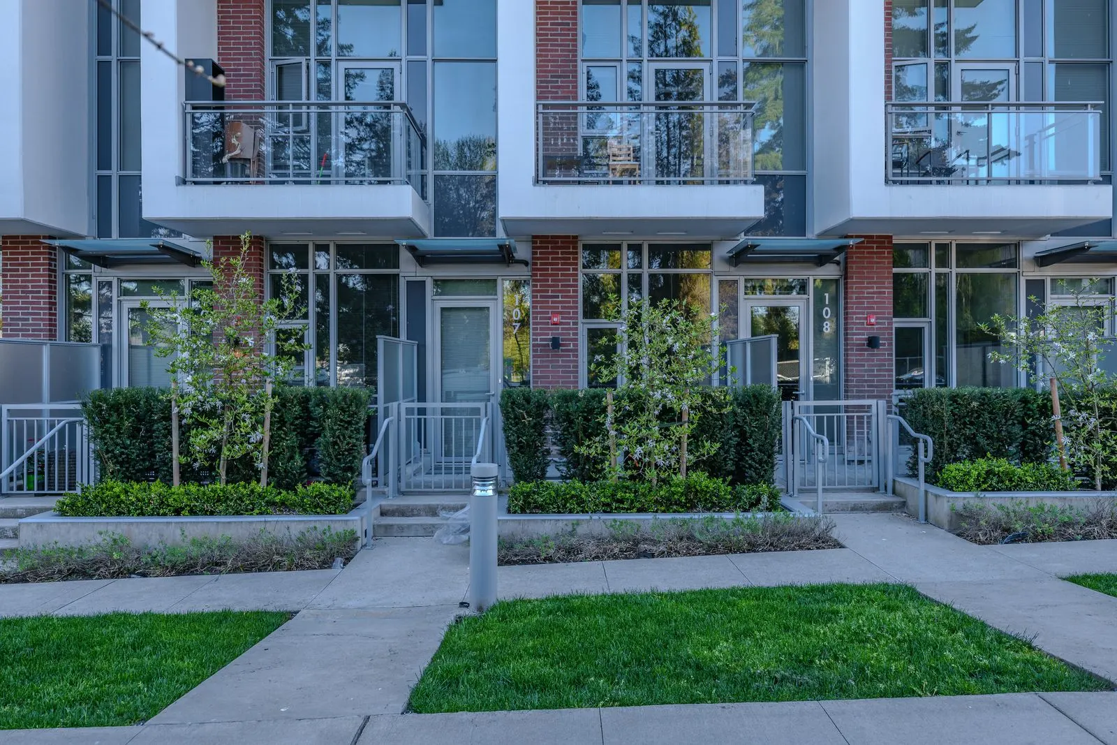 Lawn panels and planting at a row of townhome entries at Evolve