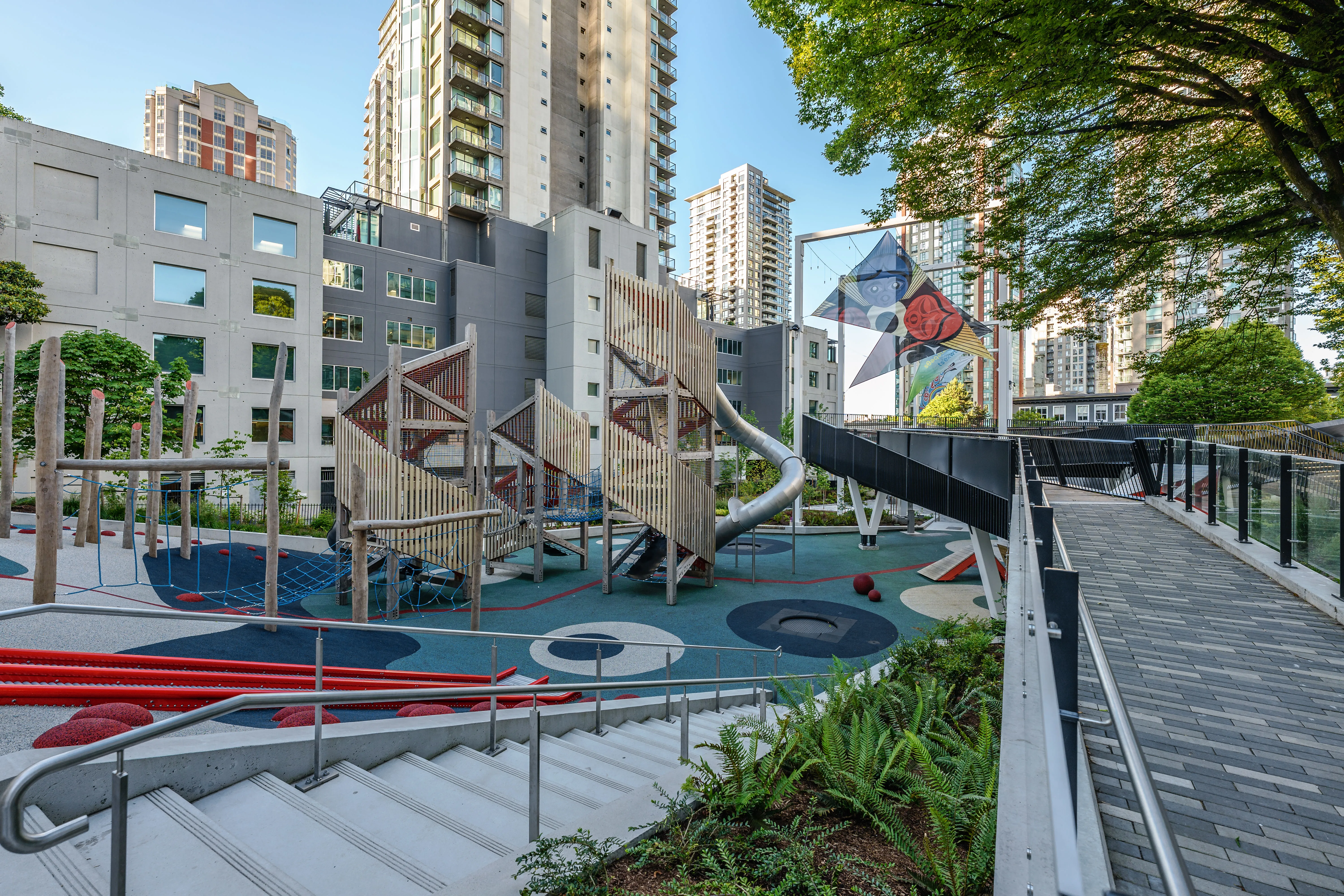 Playground with climbing structures beside a ramp at Rainbow Park Downtown