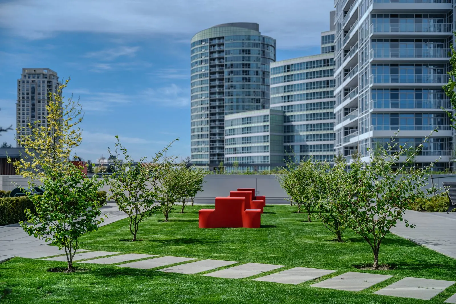 Rooftop lawn, young trees and red seating at Station Square 2 and 3