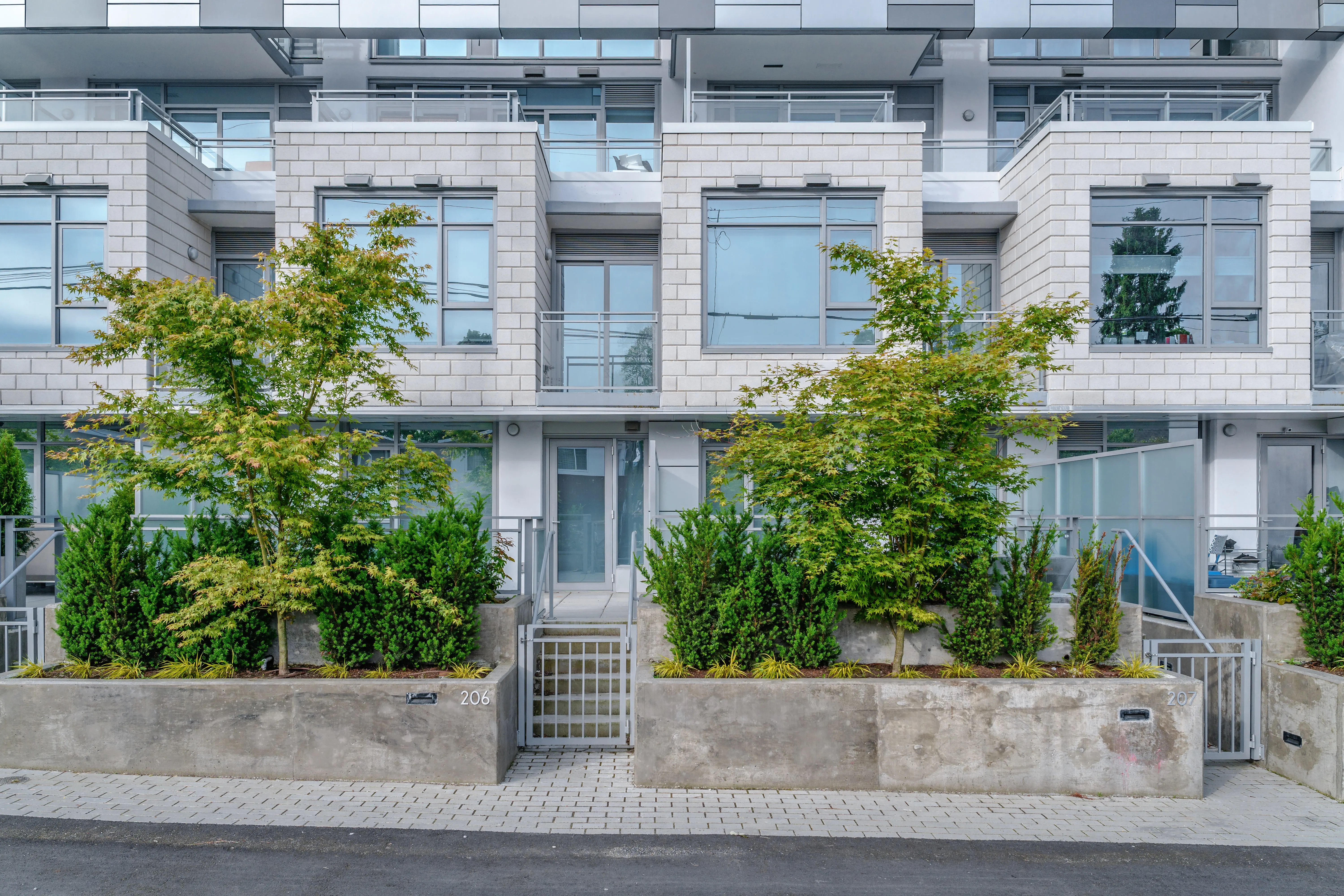 Shrubs in raised planters along townhome patios at The Windsor