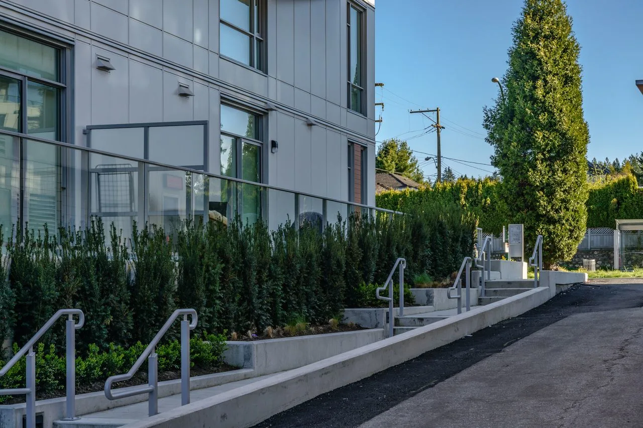 Hedge and stair railings along a residential building at Marquise
