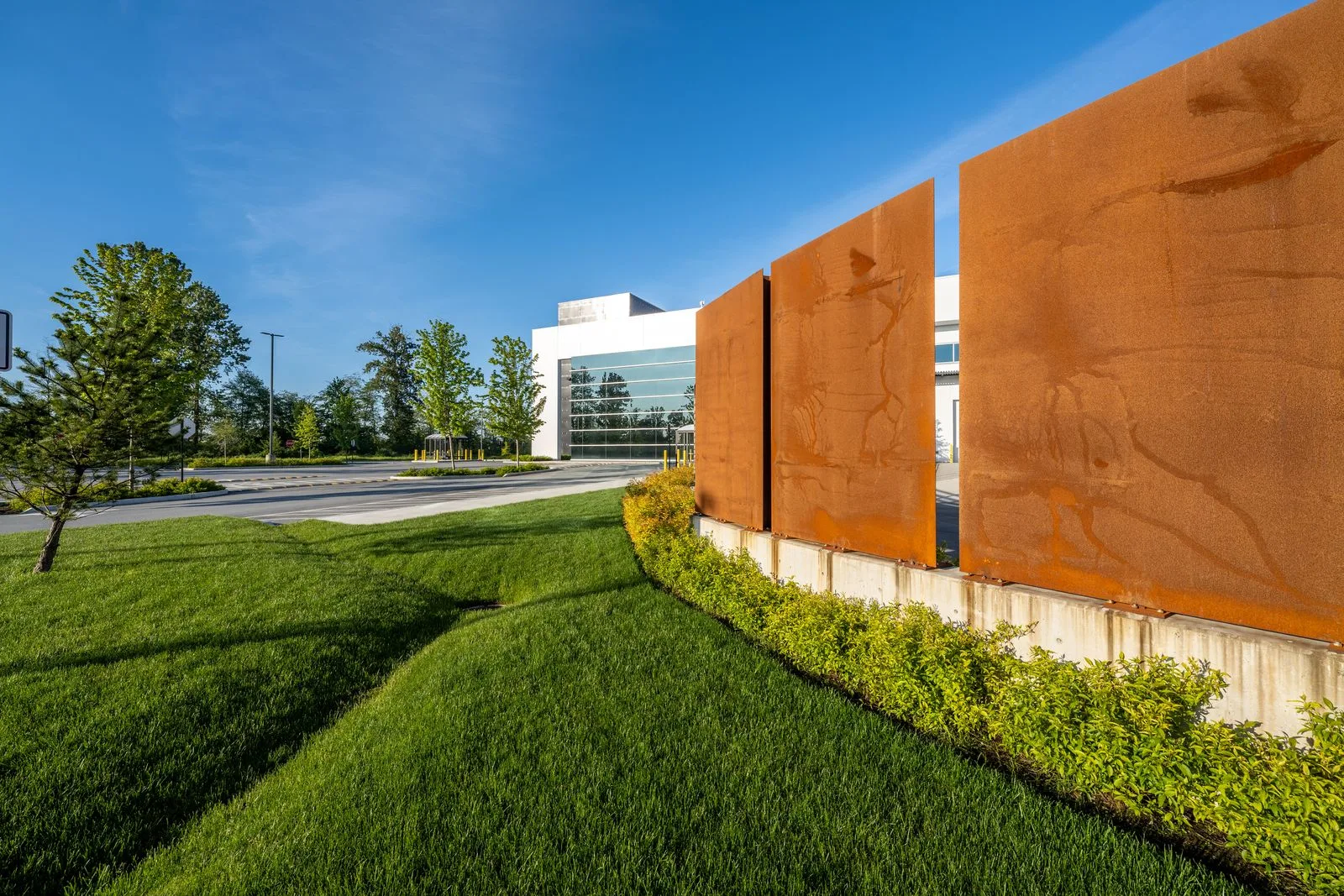 Lawn and weathering steel panels along a planted edge at Riverbend Amazon Warehouse