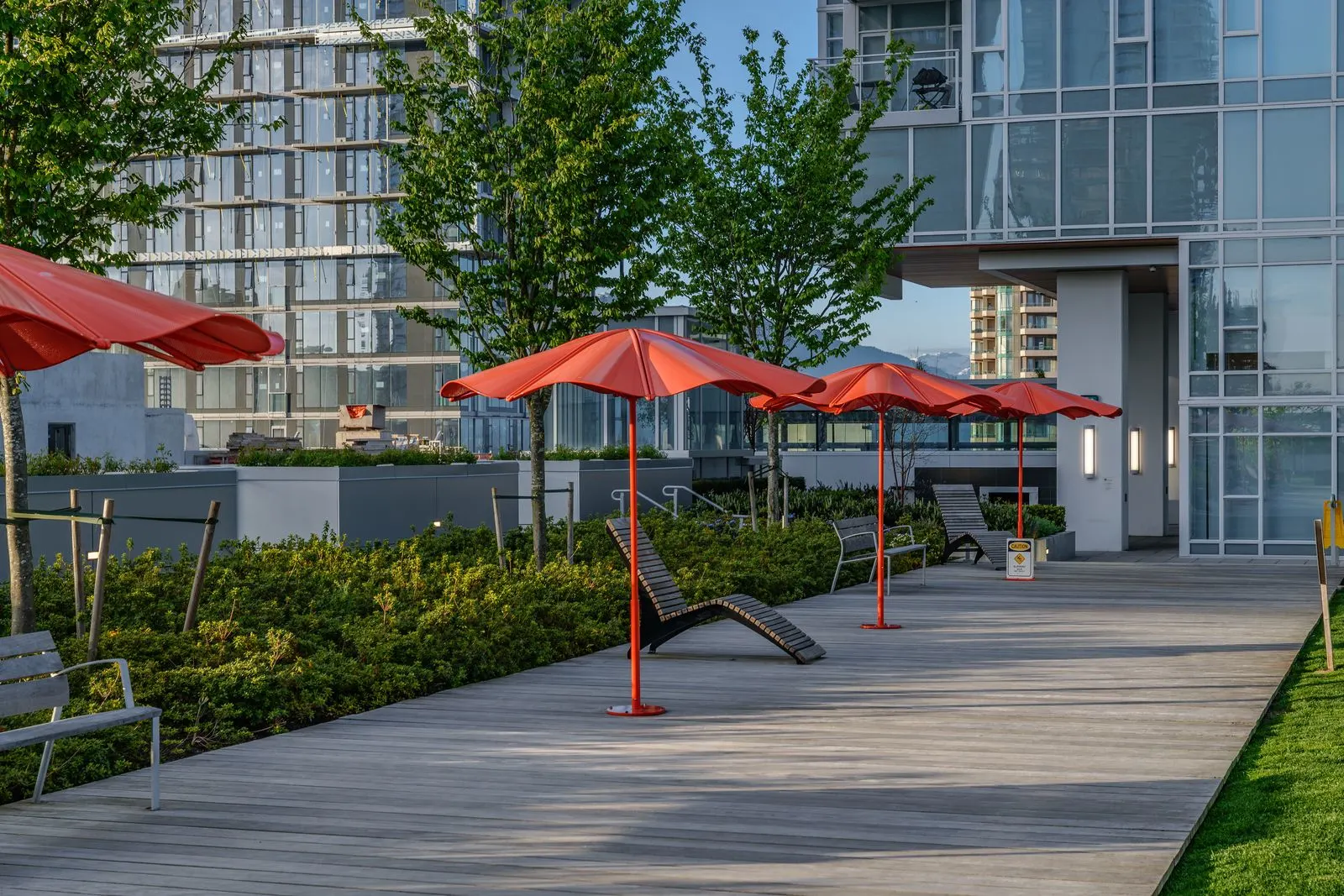 Red umbrellas and lounge chairs on a planted deck at Station Square 2 and 3