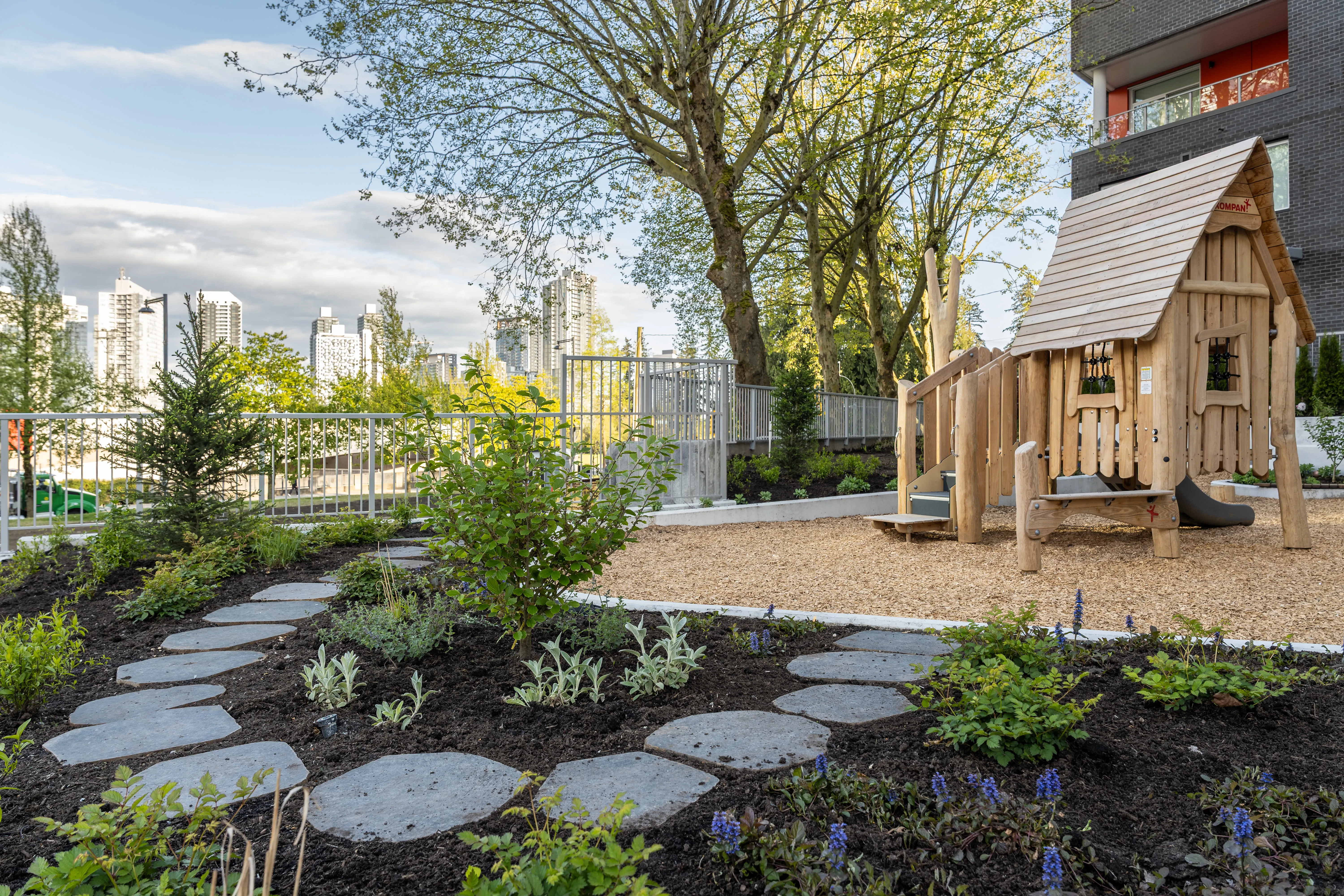 Stepping stone path through planting to a timber playhouse at The Holland II