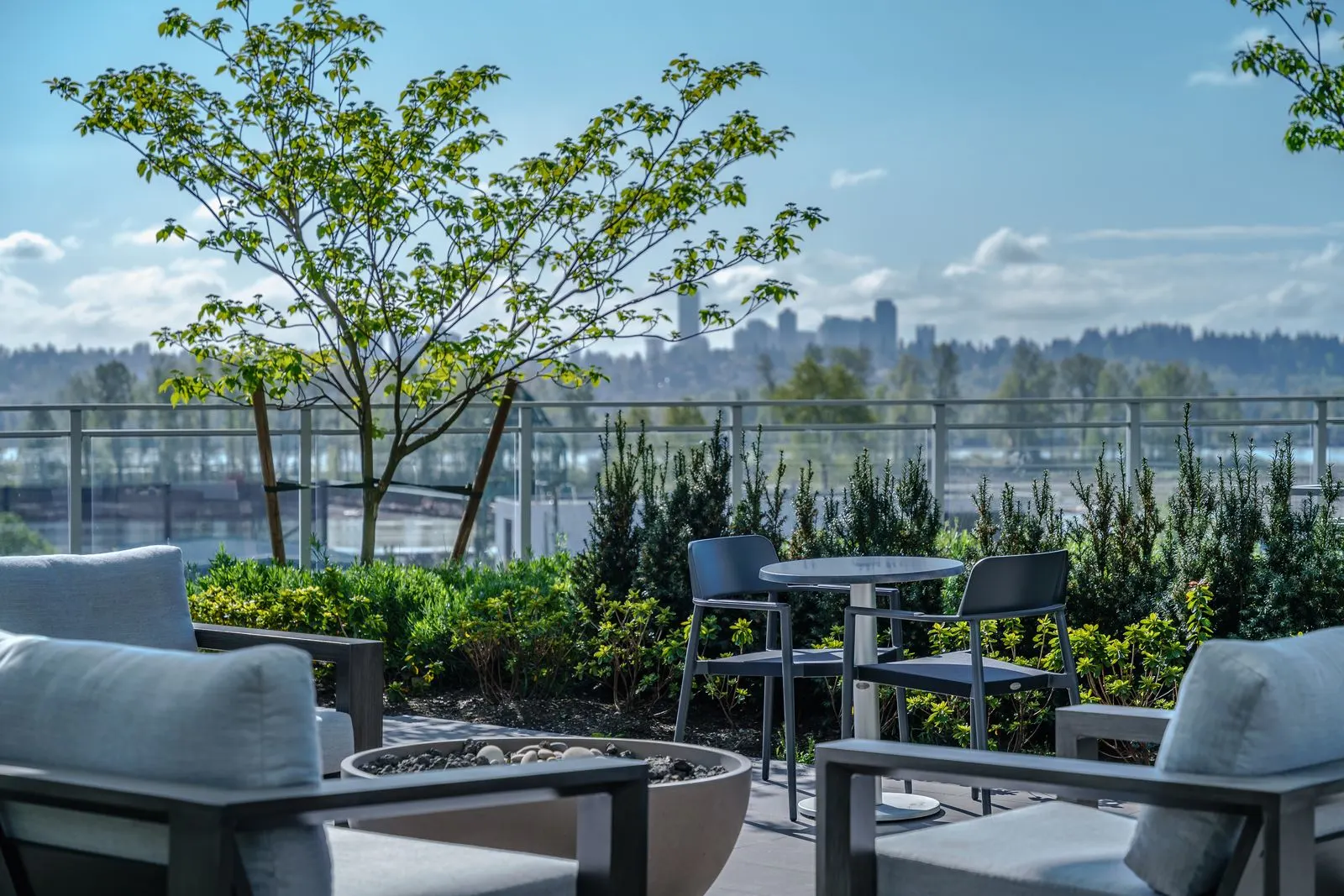Lounge seating and tables on a rooftop with city views at Brewery District 6