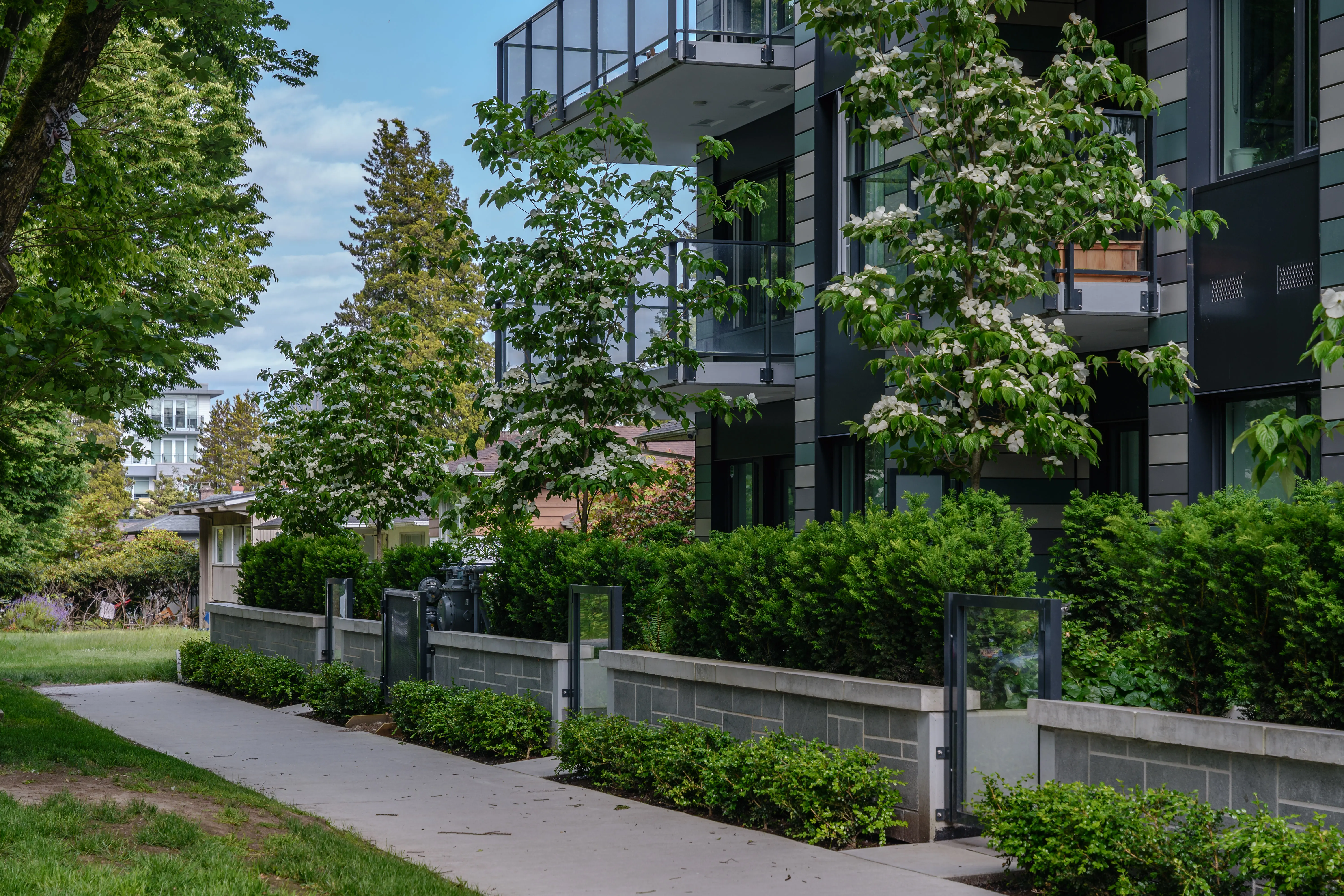 Hedges, trees and walkway along a residential building at Parkhouse