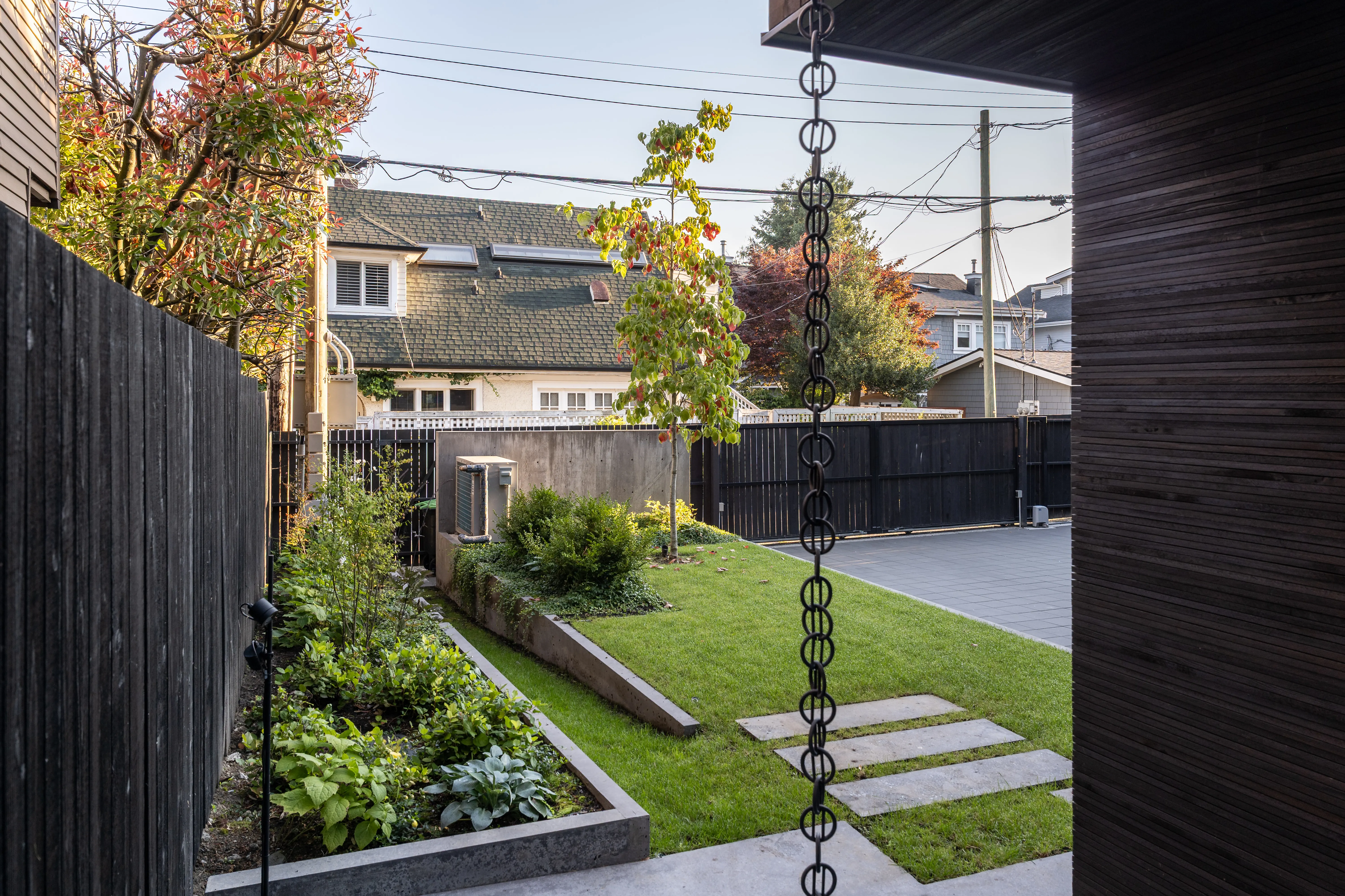 Side yard lawn with stepping stones and a rain chain at West 1st