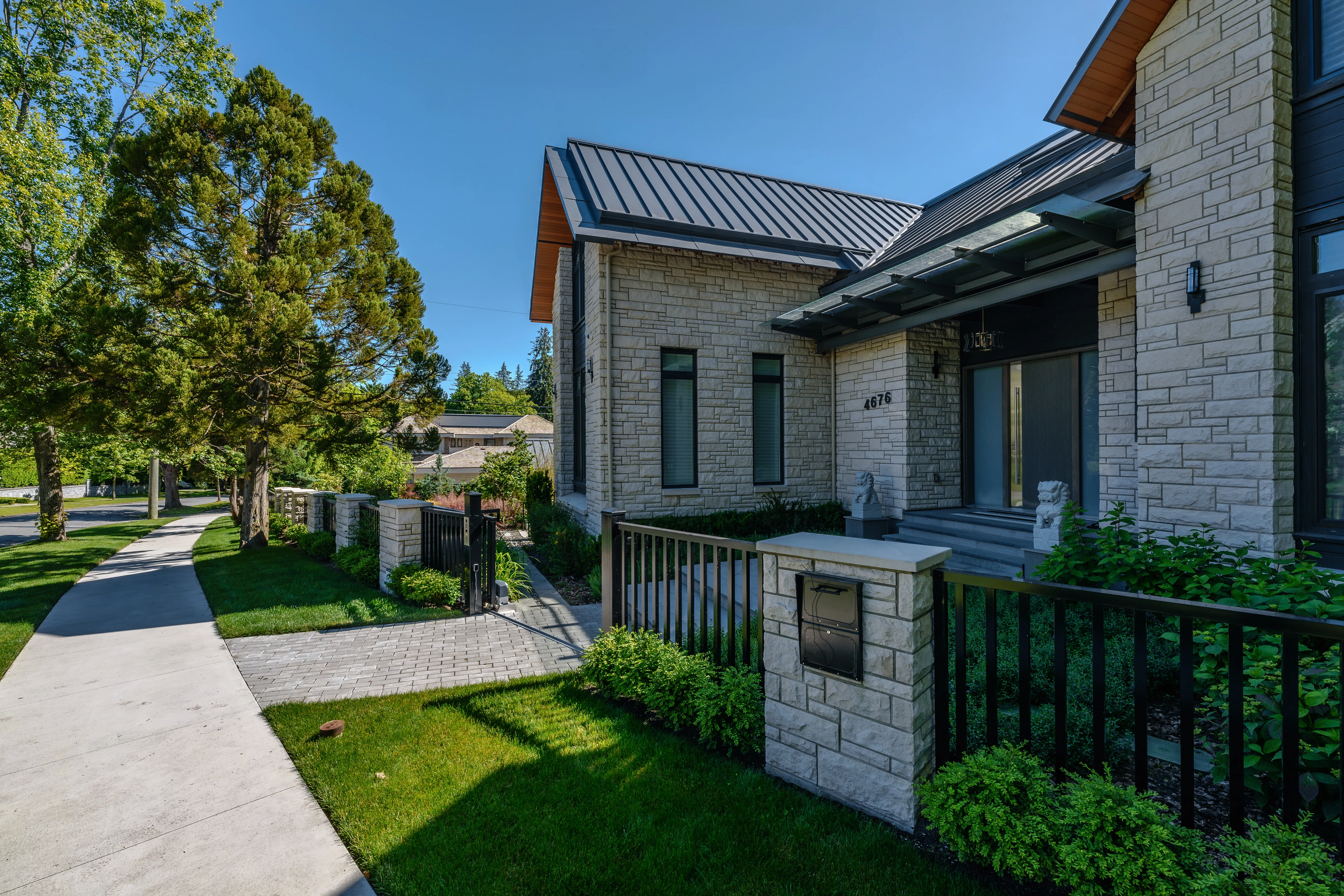 Front lawn, walkway and fence at a stone-clad house at Hudson Street