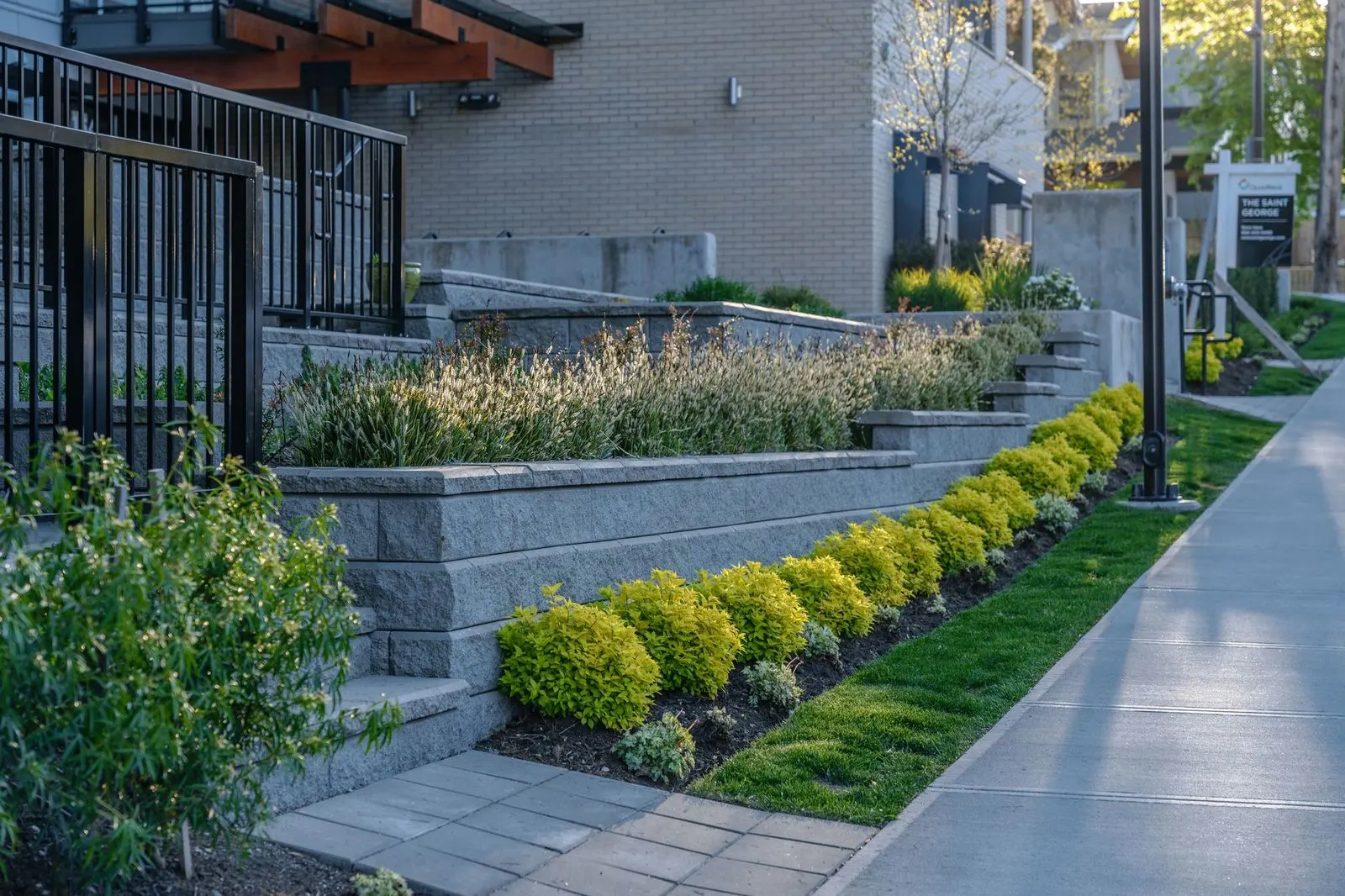 Block retaining walls and shrub planting along a sidewalk at The Saint George
