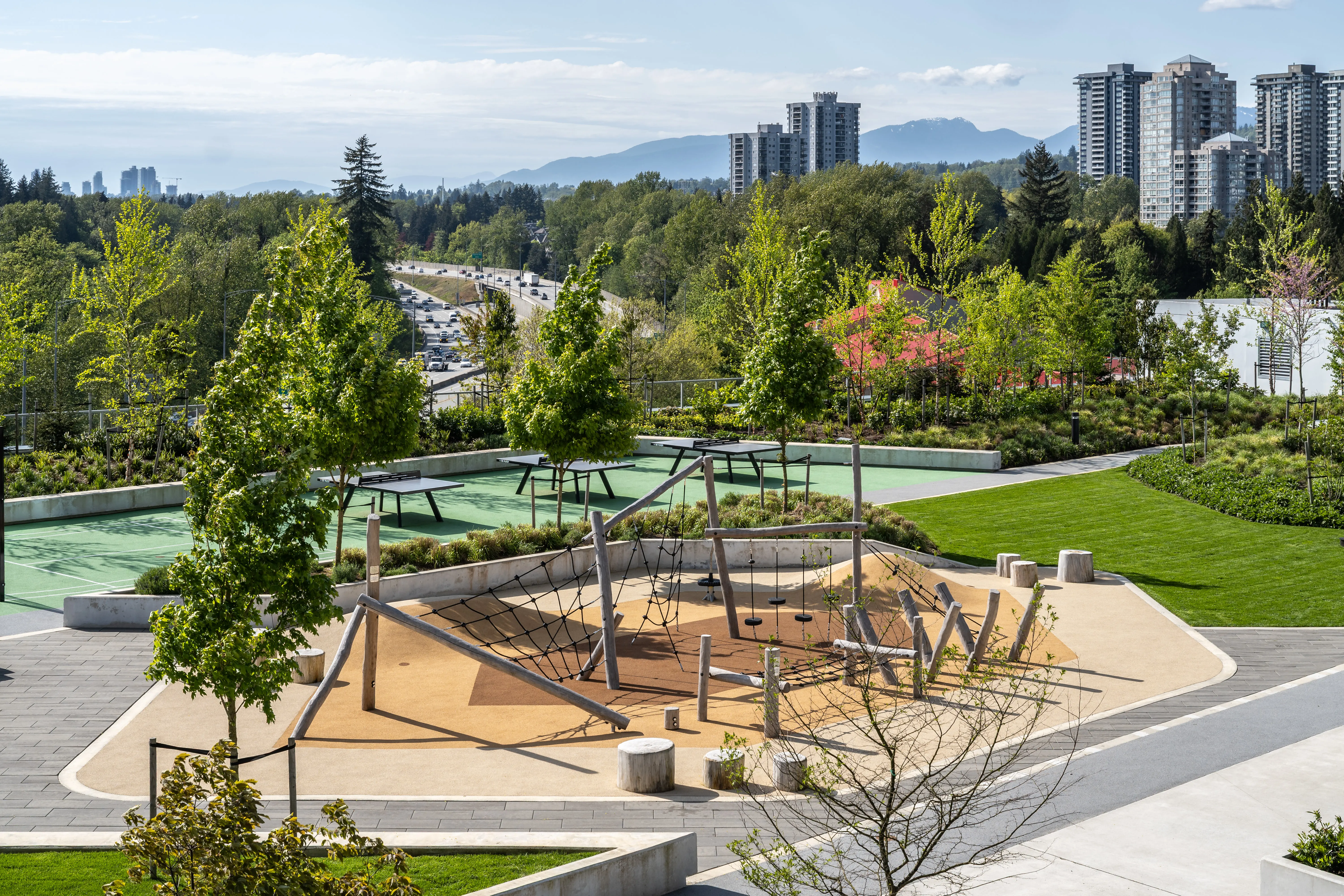 Rooftop play area with timber structure among planting at Soco