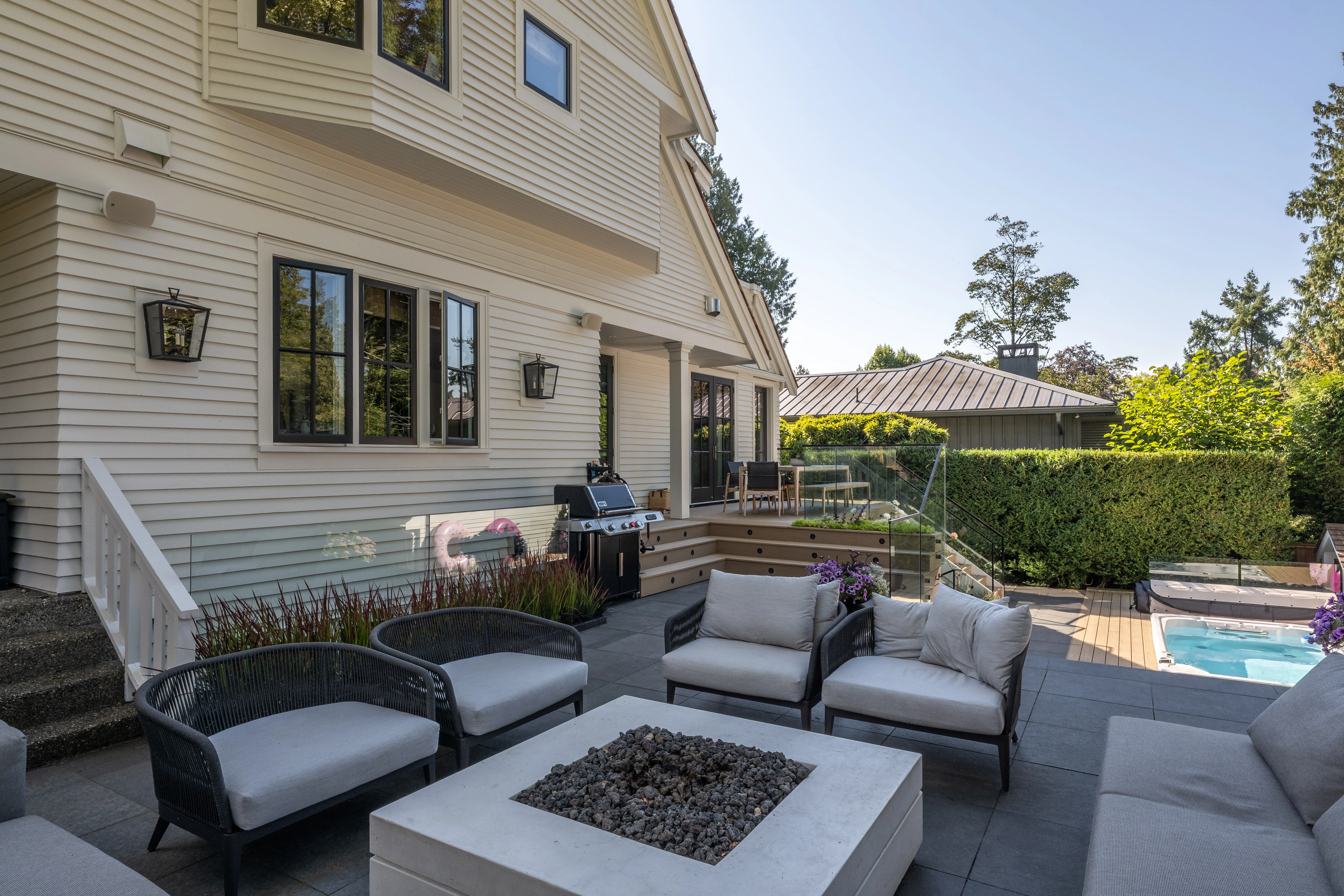 Patio with outdoor sofas around a fire table at MacKenzie