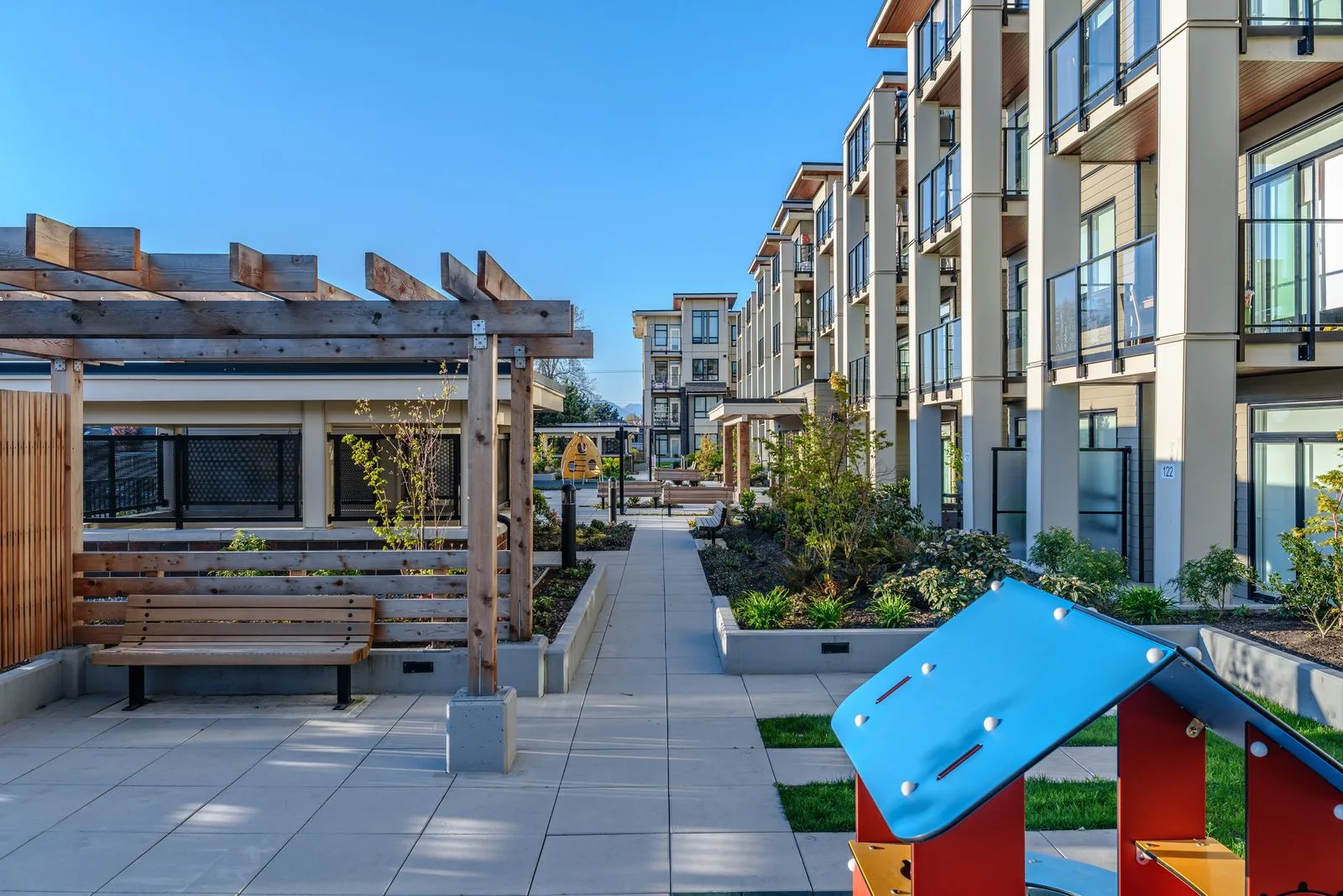 Courtyard with a small playhouse, pergola and planting at Spark